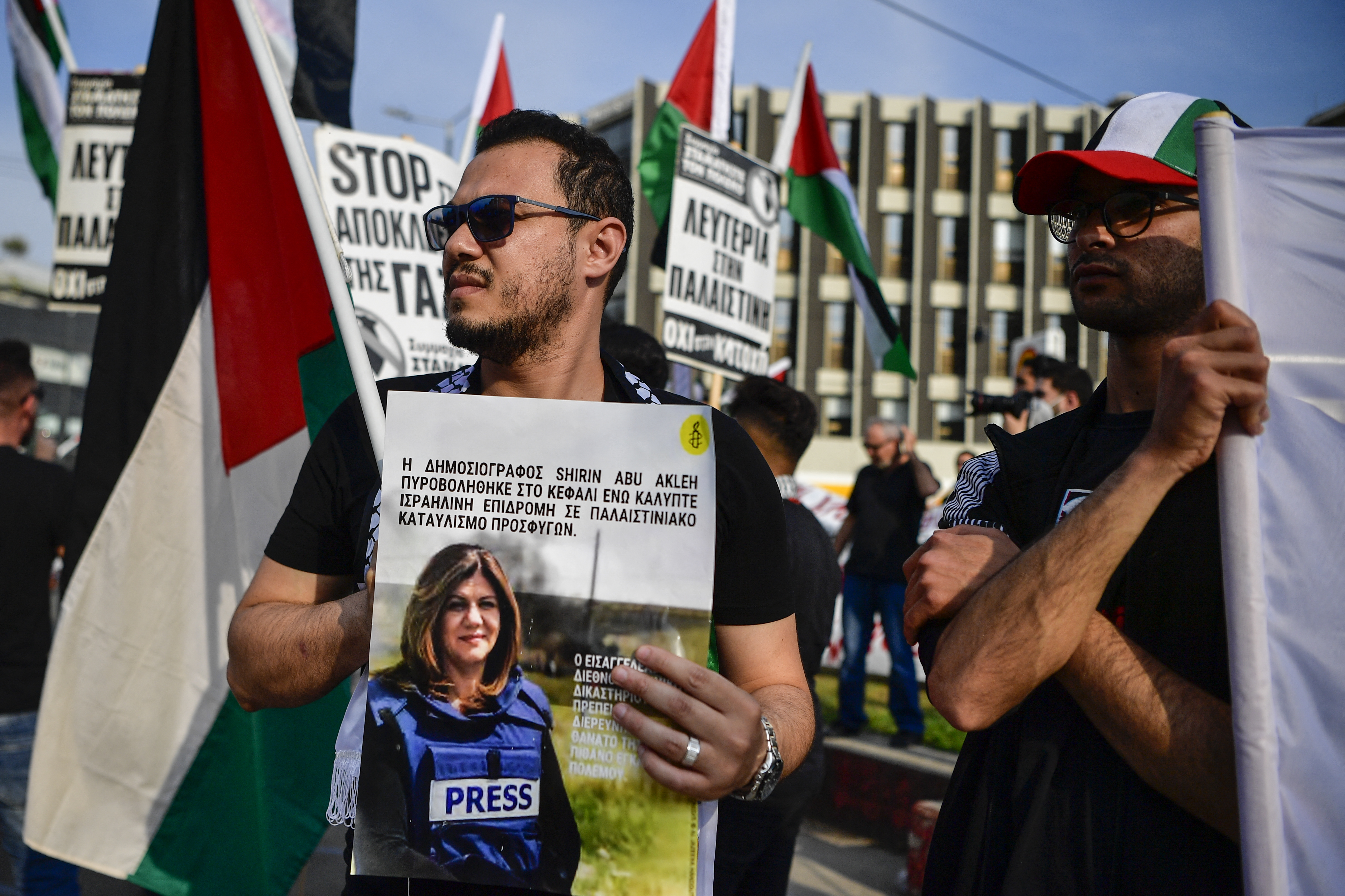 A protester holds a picture of slain Al Jazeera reporter Shireen Abu Akleh during a demonstration in front of the Israeli embassy to support Palestinians, in Athens on May 16, 2022.