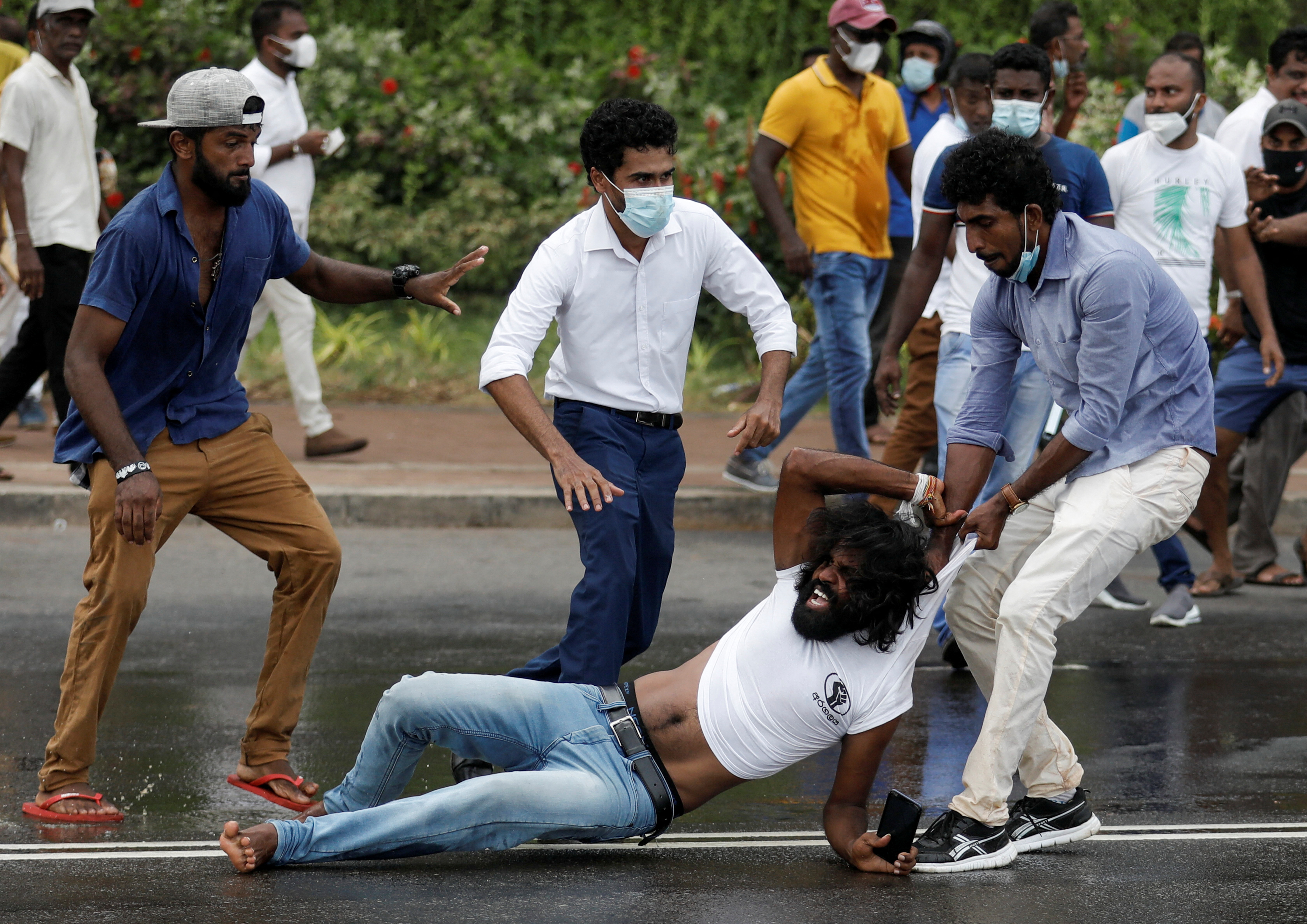Three men attack a man and drag him along the ground