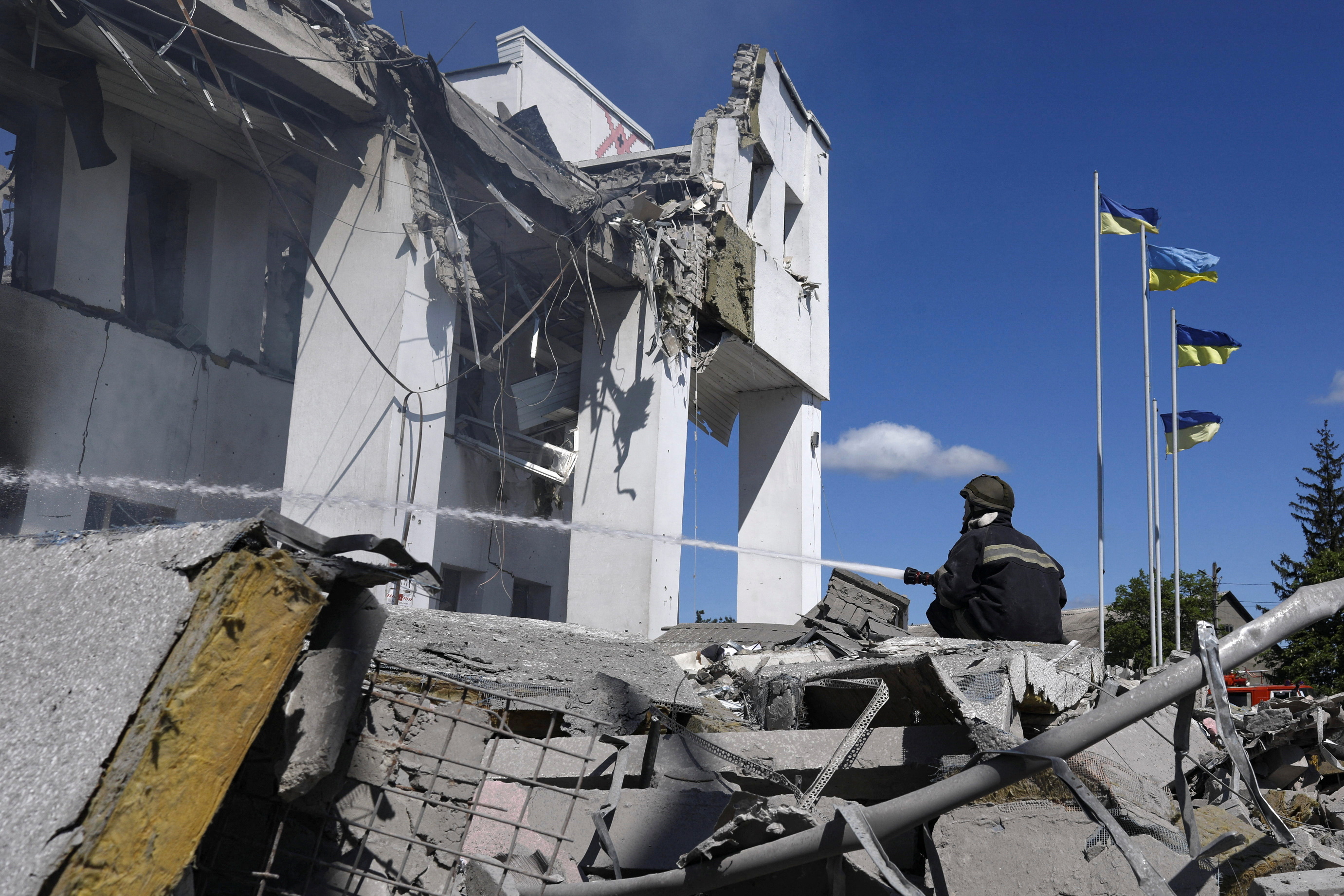 A firefighter is seen trying to extinguish a blaze after a Russian bombing near Kharkiv