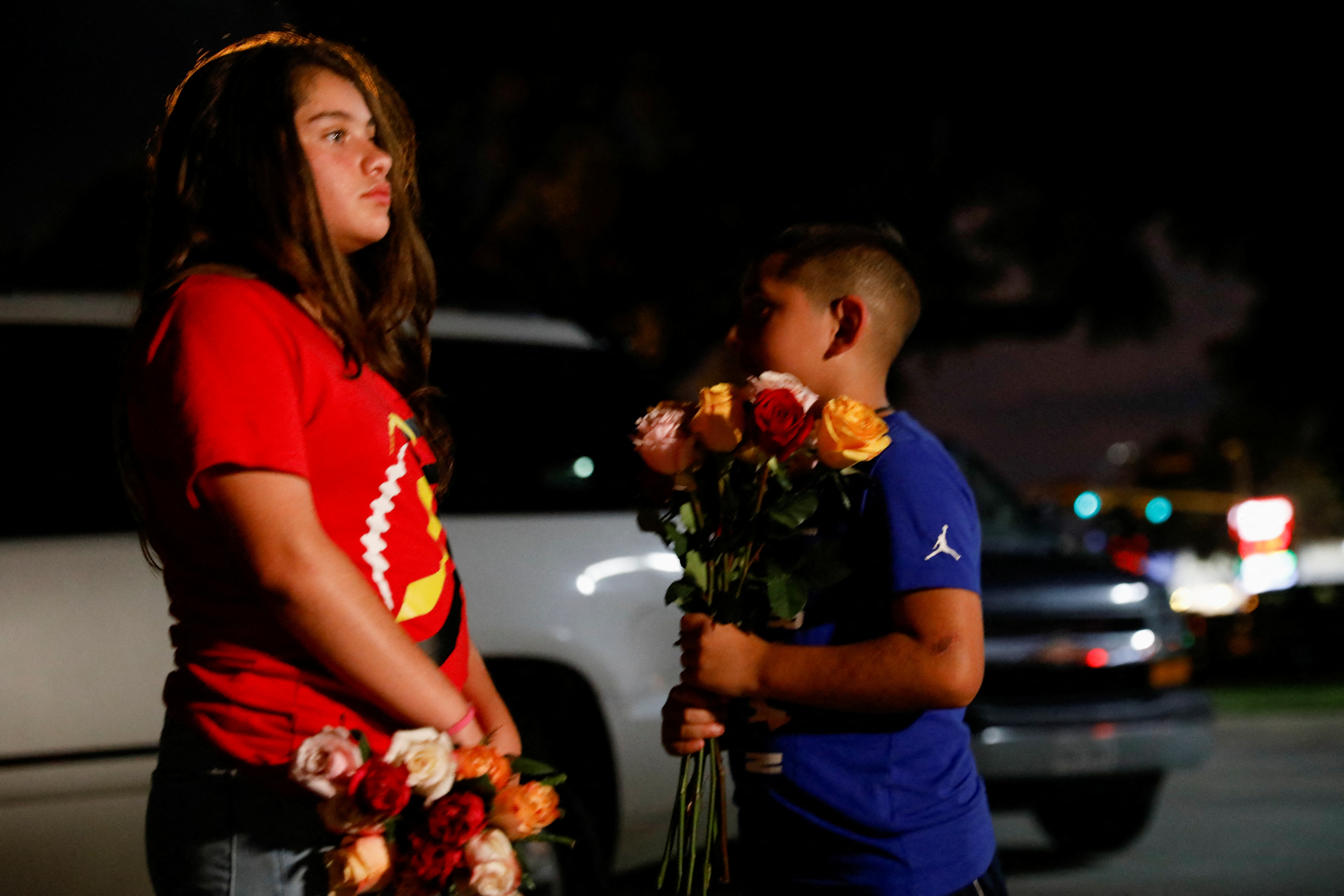 Children stand outside the Ssgt Willie de Leon Civic Center, where students of the Robb Elementary School after a gunman went on a rampage in their school [Marco Bello/Reuters