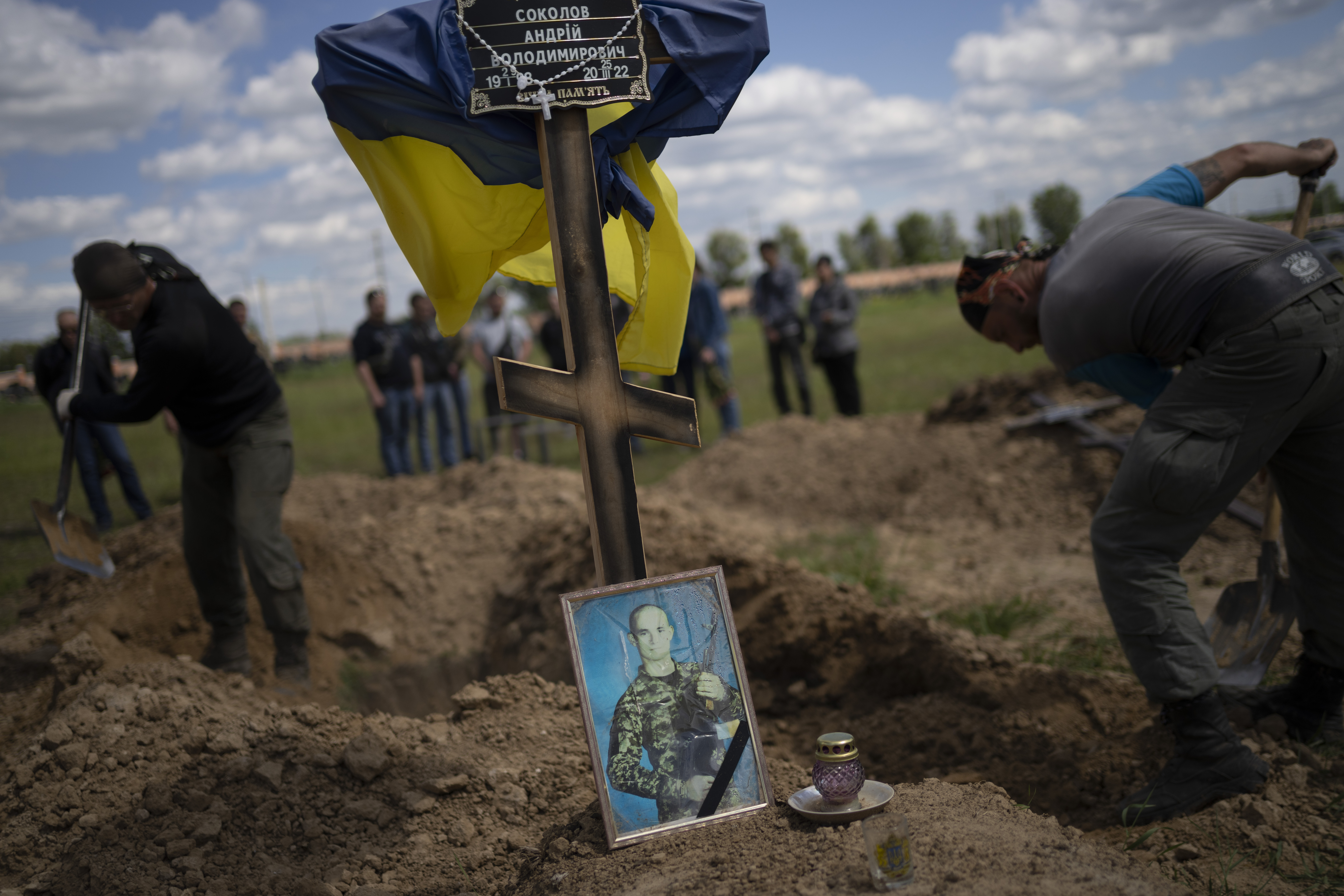 A Ukrainian service member is buried next to his comrade in Kharkiv in eastern Ukraine