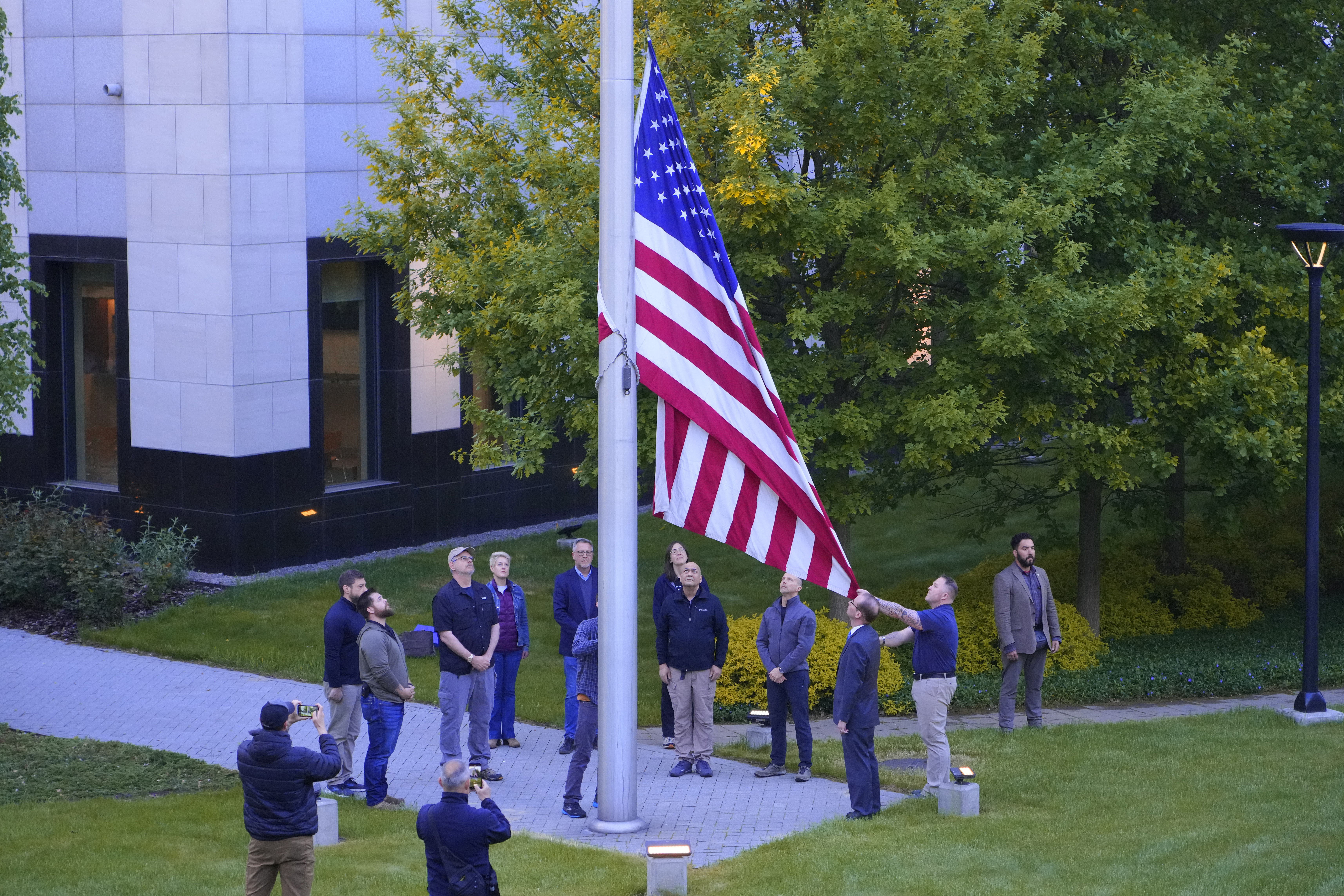 Employees of the US embassy in Ukraine raise the US flag at the US embassy in Kyiv, Ukraine, Wednesday, May 18, 2022