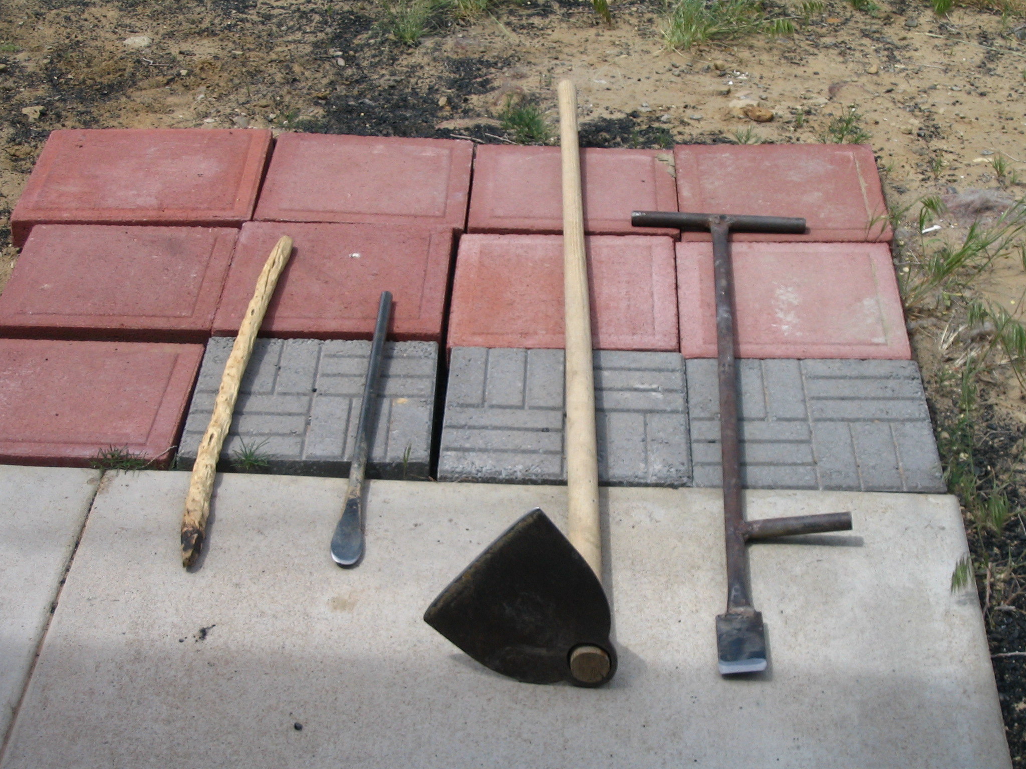 Hopi traditional planting tools: From left to right, a traditional planting stick made from greasewood, a modern metal planting stick, a hoe, and a foot planting tool