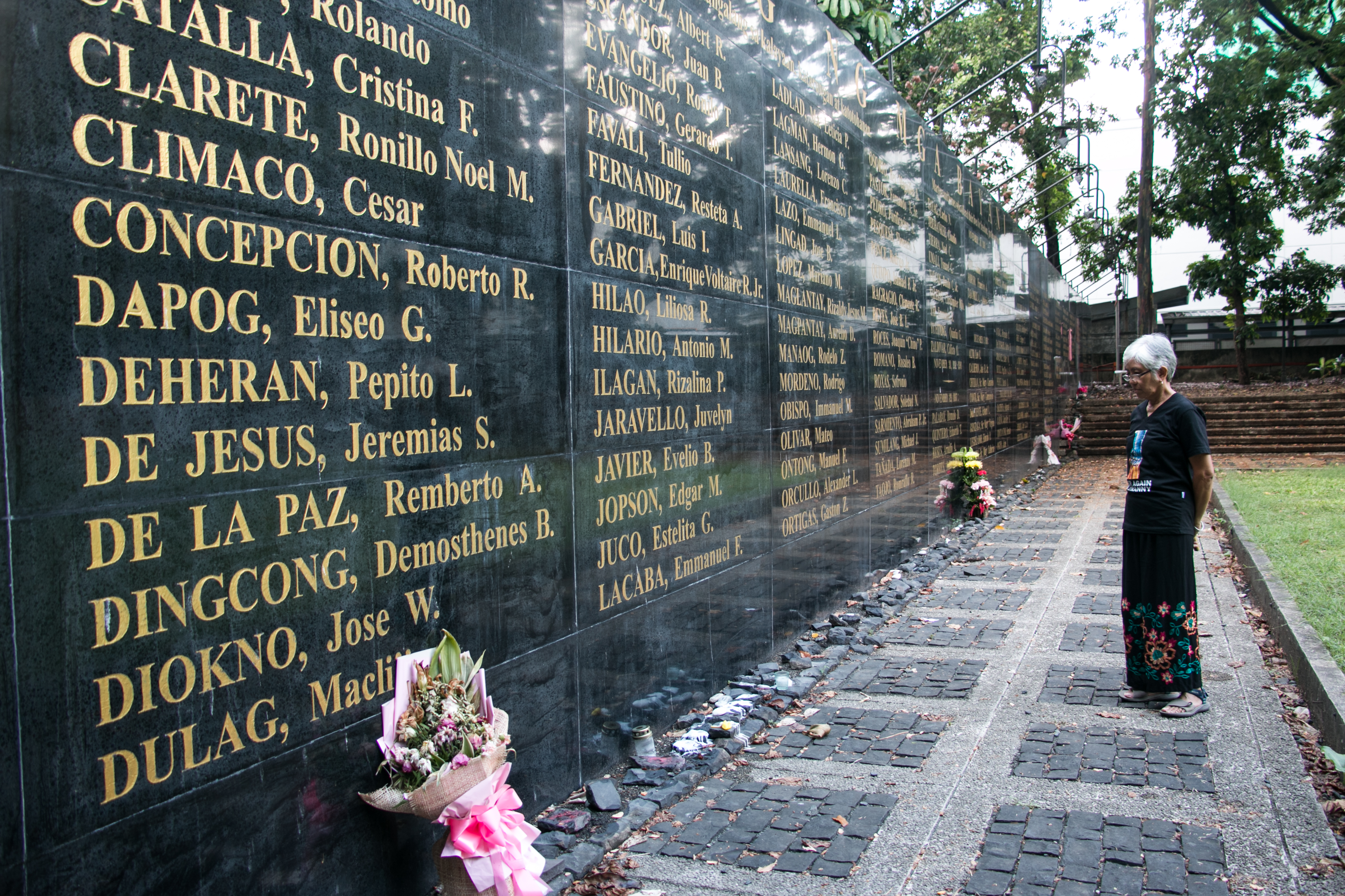 A long Wall of Remembrance stands in the Bantayog ng Mga Bayani (Monument of Heroes), where the names of 320 Filipinos who stood up against the dictatorship of Ferdinand Marcos are etched. Days after his son won the presidency, people began leaving flowers and lighting candles to honour the dead