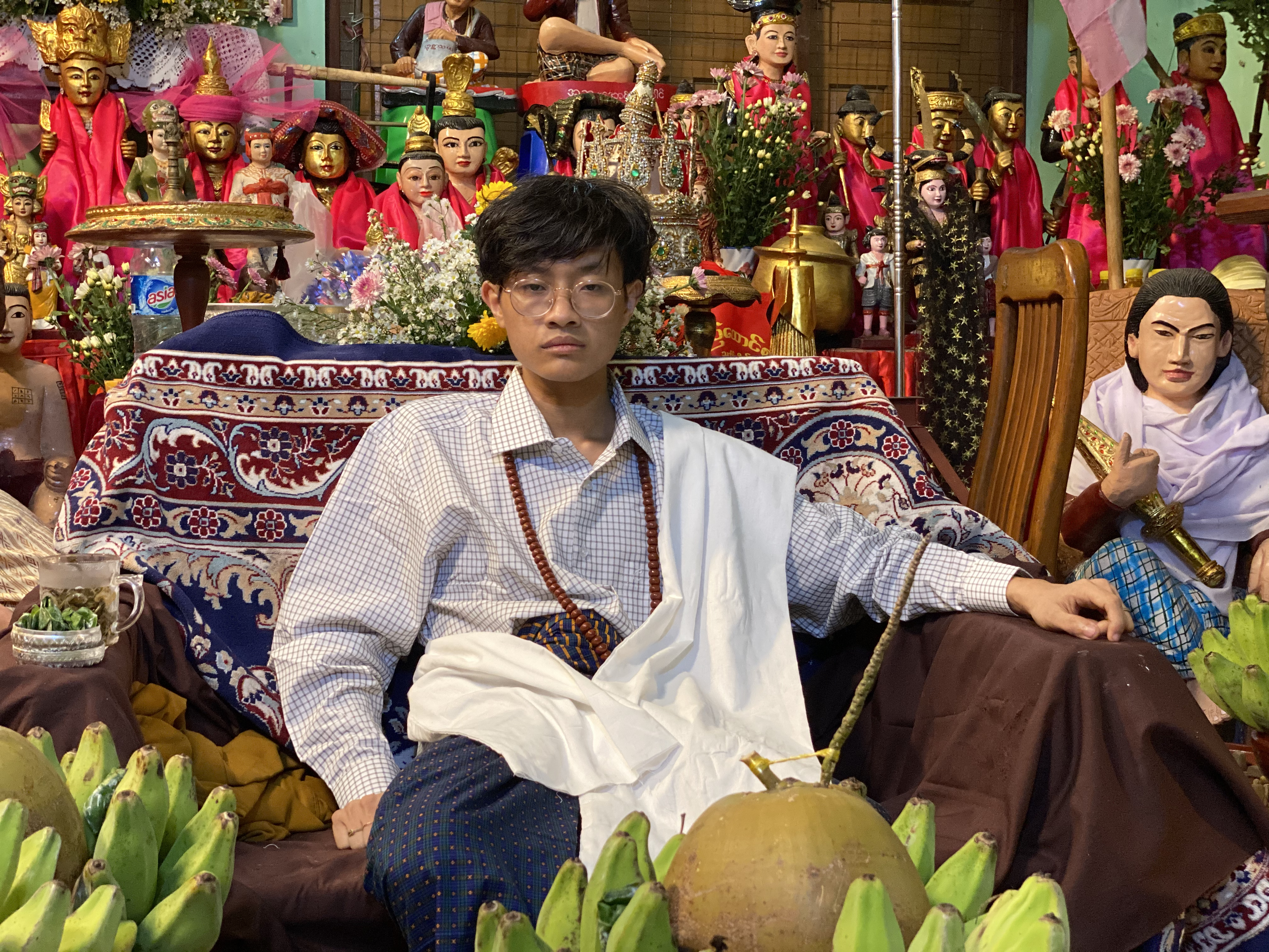 A wizard sits in an elaborately decorated room in Myanmar