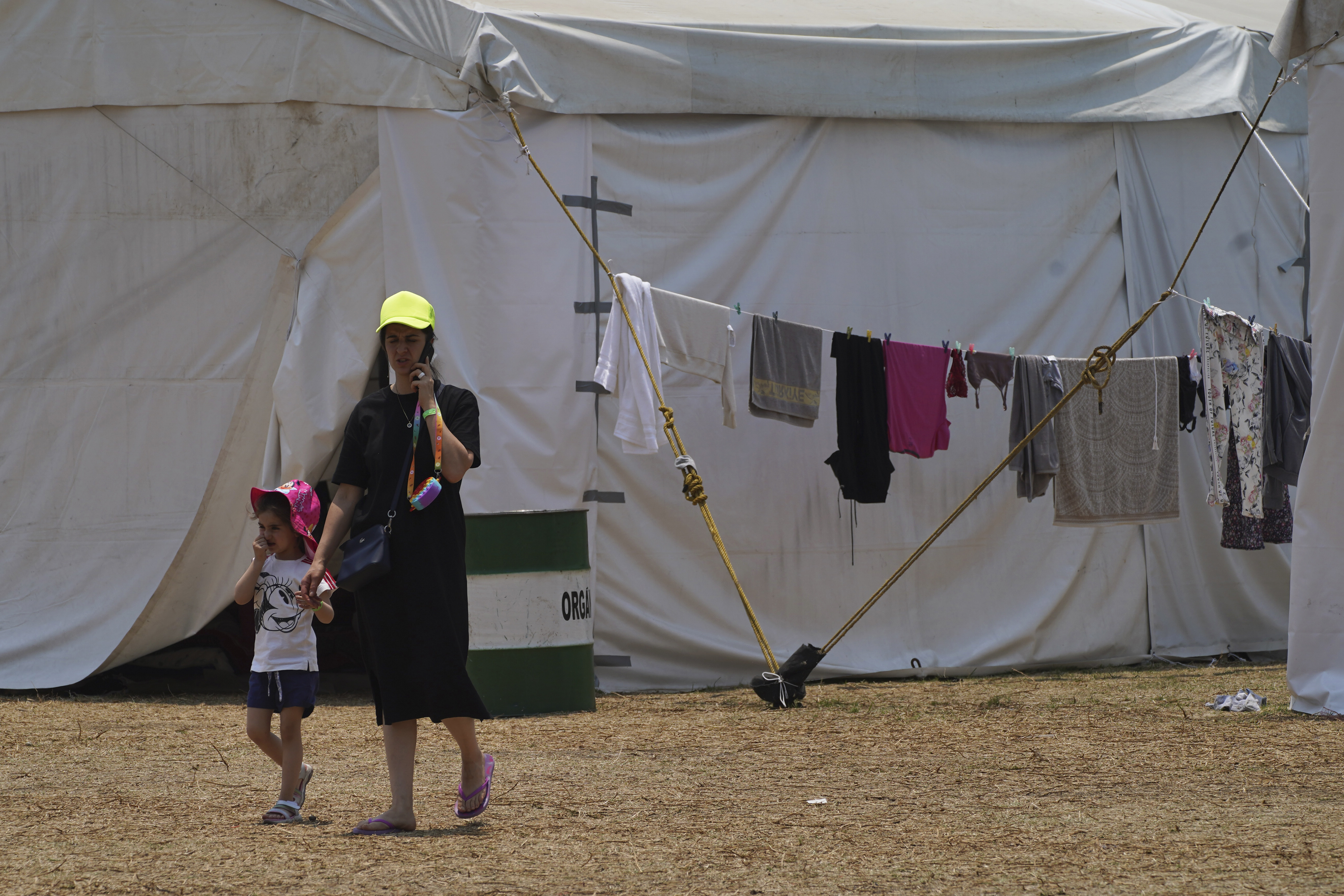 A Ukrainian refugee walks with her child at a camp in Utopia Park in Iztapalapa, Mexico City, Monday, May 2, 2022 