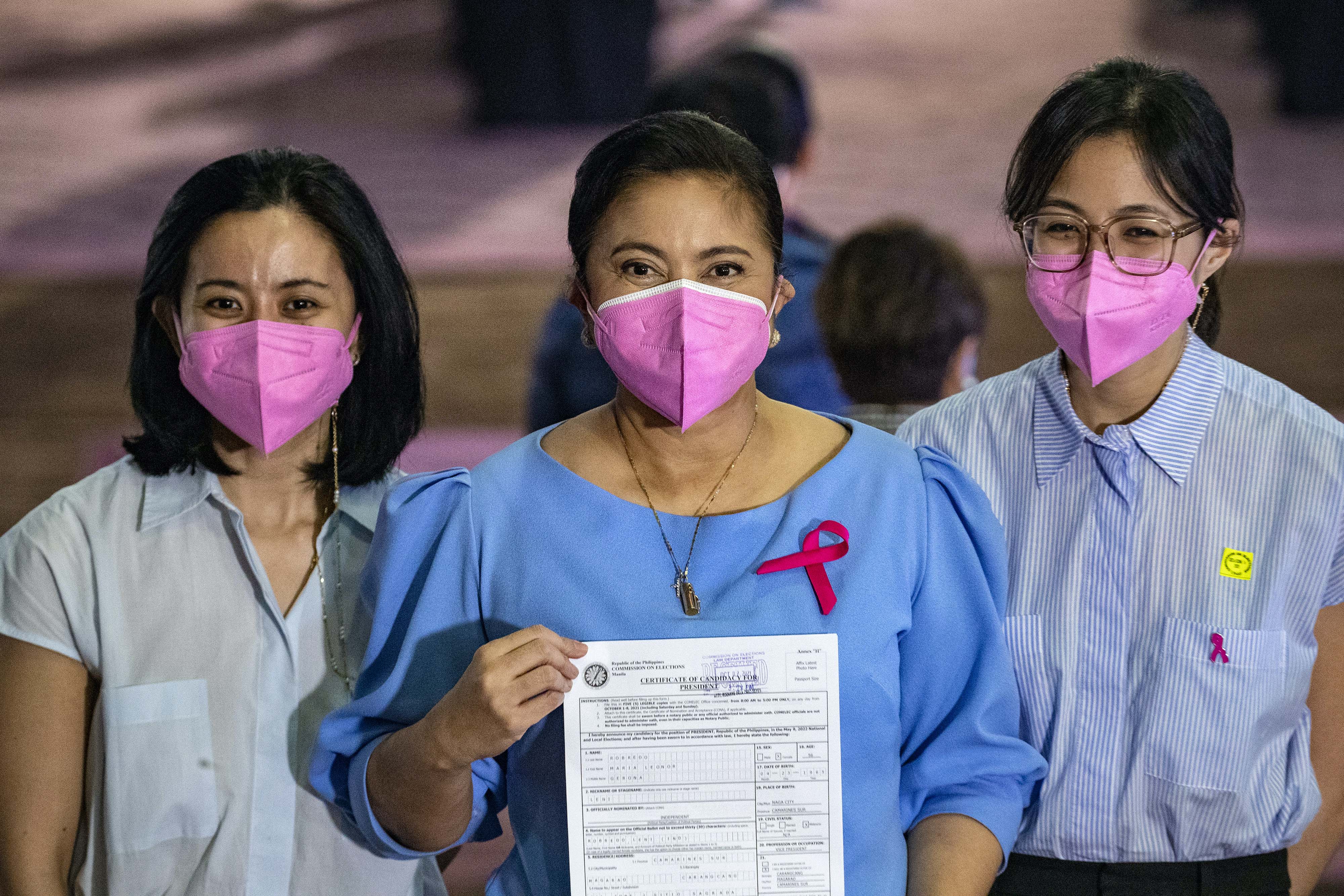 Some voters say they admire Robredo, seen here with two of her three daughters as he filed her candidacy papers, for bringing up her children on her own after her husband was killed in a plane crash in 2012