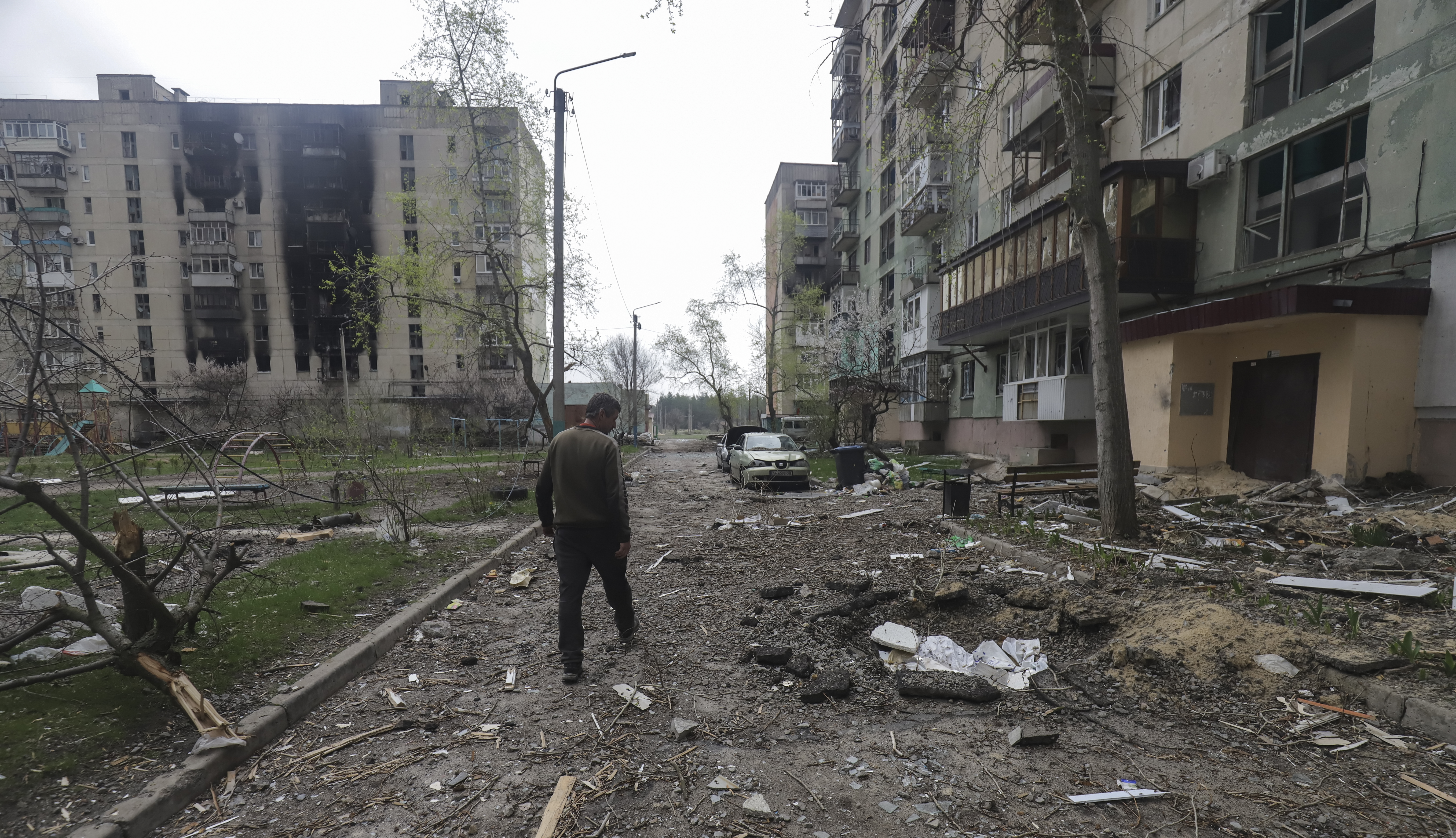 A man walks past a residential building damaged during shelling in Severodonetsk, northwest of Luhansk, Ukraine [EPA]