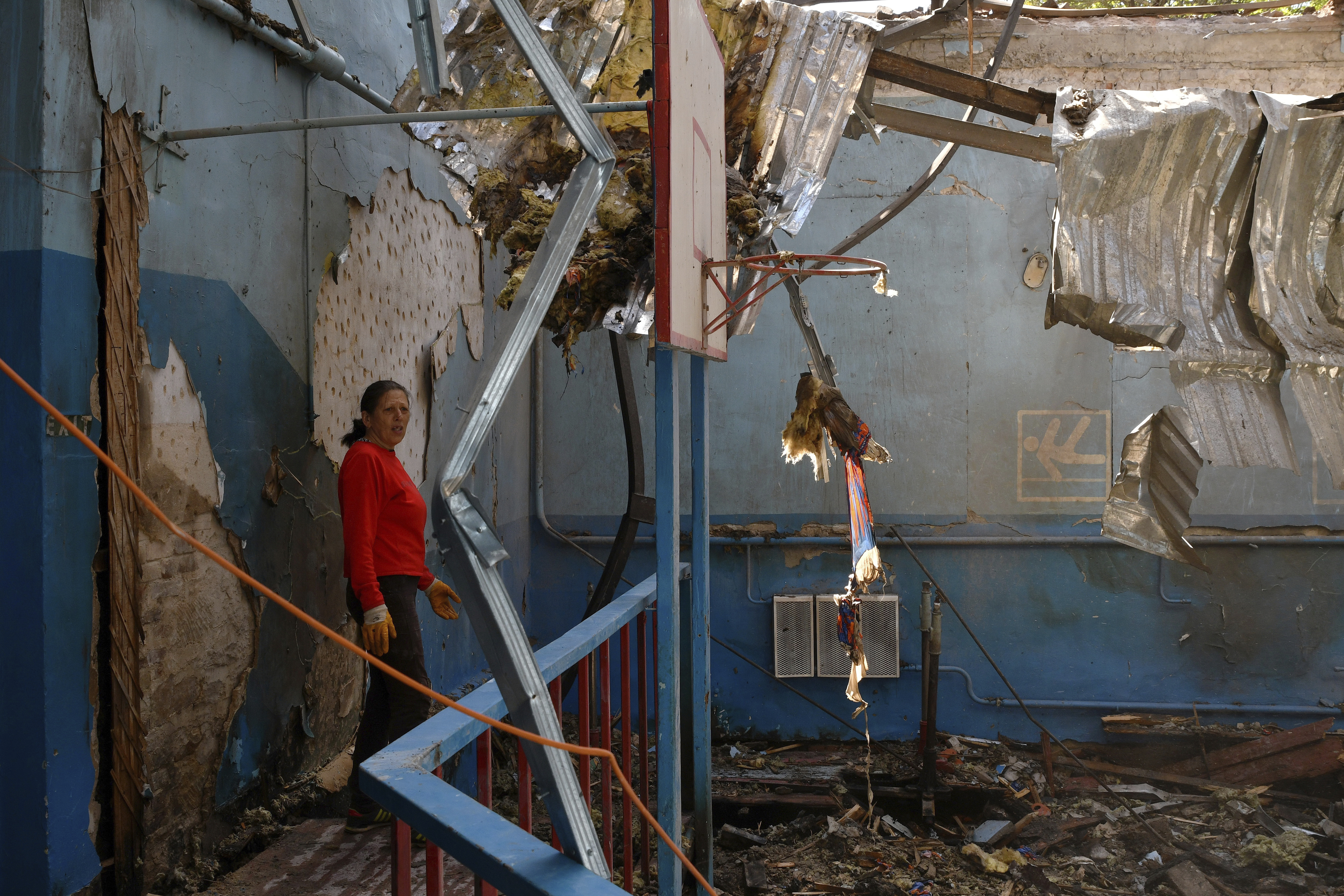 A sports teacher stands in a destroyed school gym after Russian shelling in the village of Druzhkivka, Donetsk, May 16