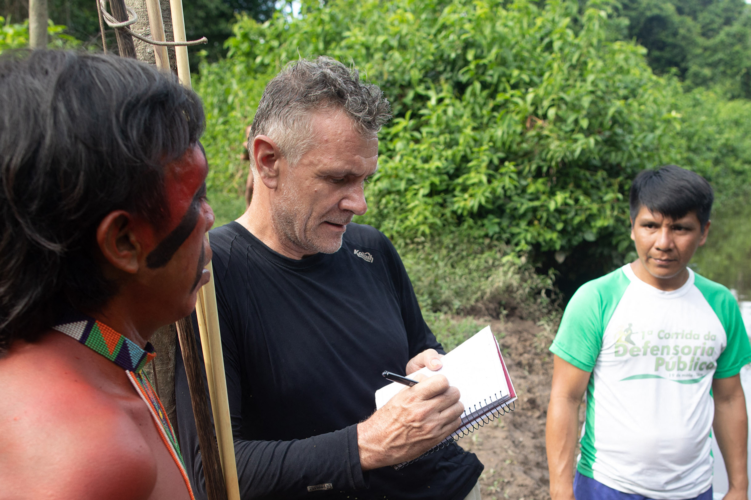 Dom Phillips (centre) talks to two Indigenous men in Aldeia Maloca Papi, in Brazil’s Roraima state, on November 16, 2019