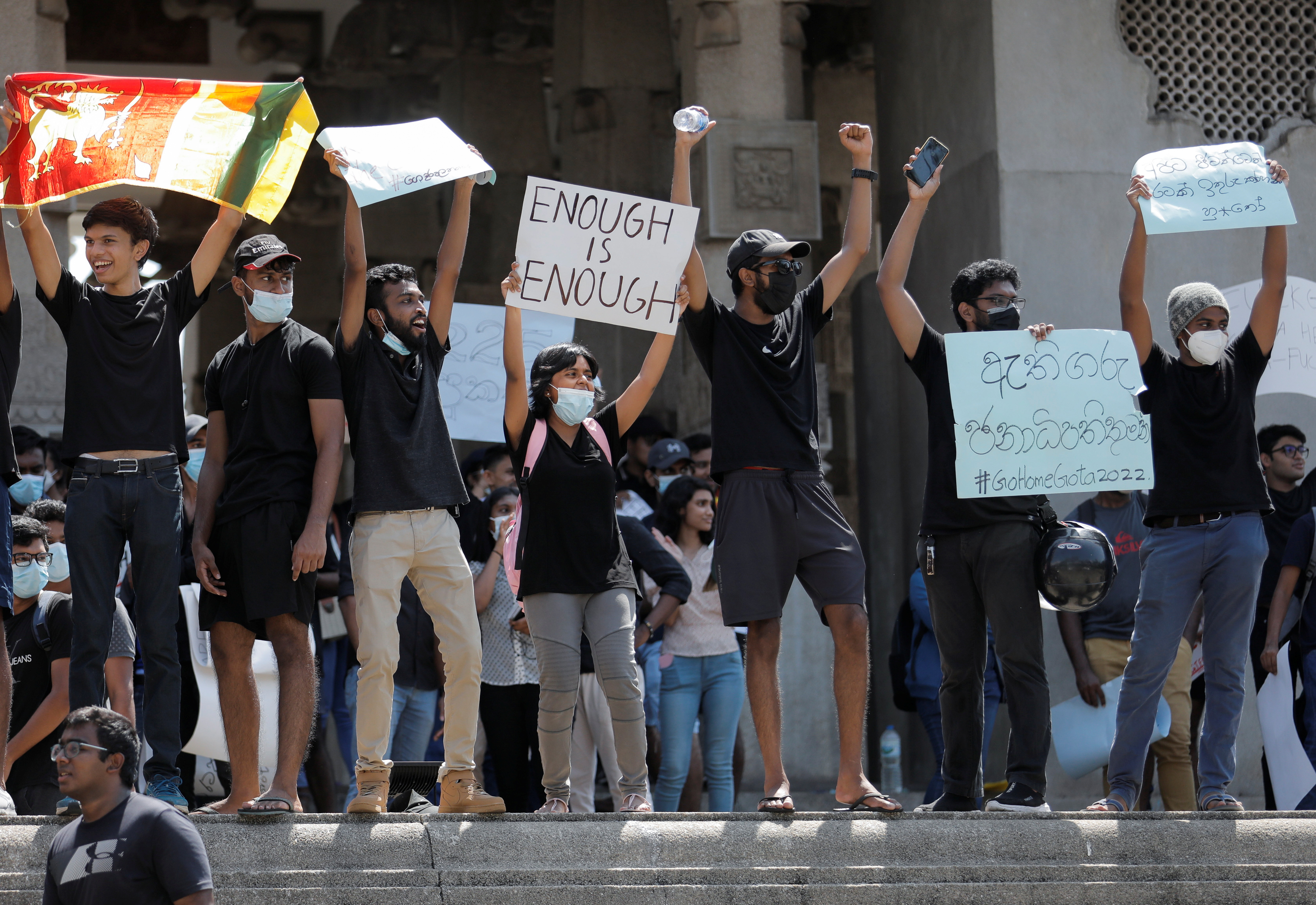 People shout slogans and hold signs during a protest in Colombo, Sri Lanka.