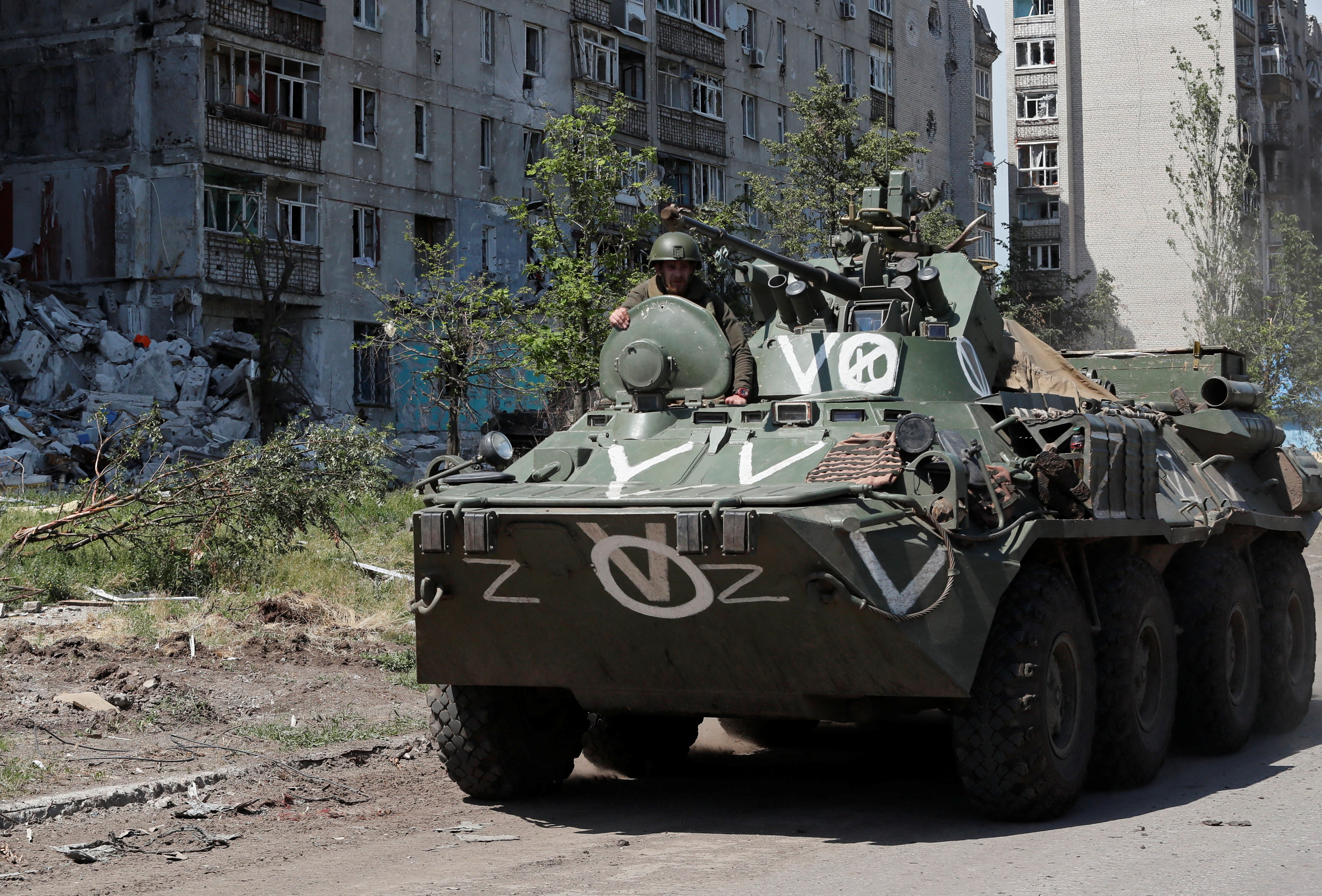 A service member of pro-Russian troops rides on top of an armoured personnel carrier during Ukraine-Russia conflict in the town of Popasna in the Luhansk Region.
