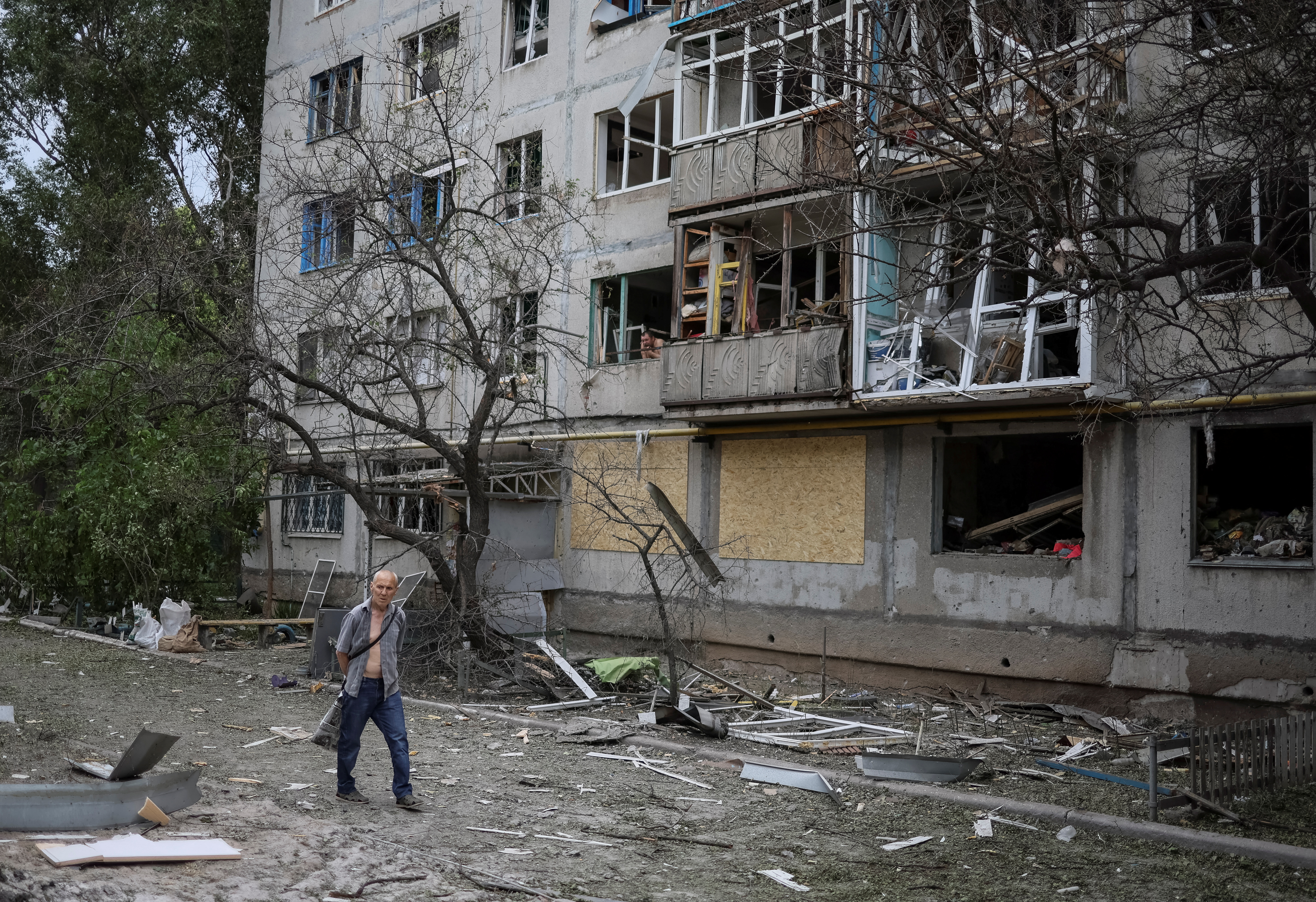 A local resident walks in front of an apartment building destroyed in a missile attack in Bakhmut, Ukraine