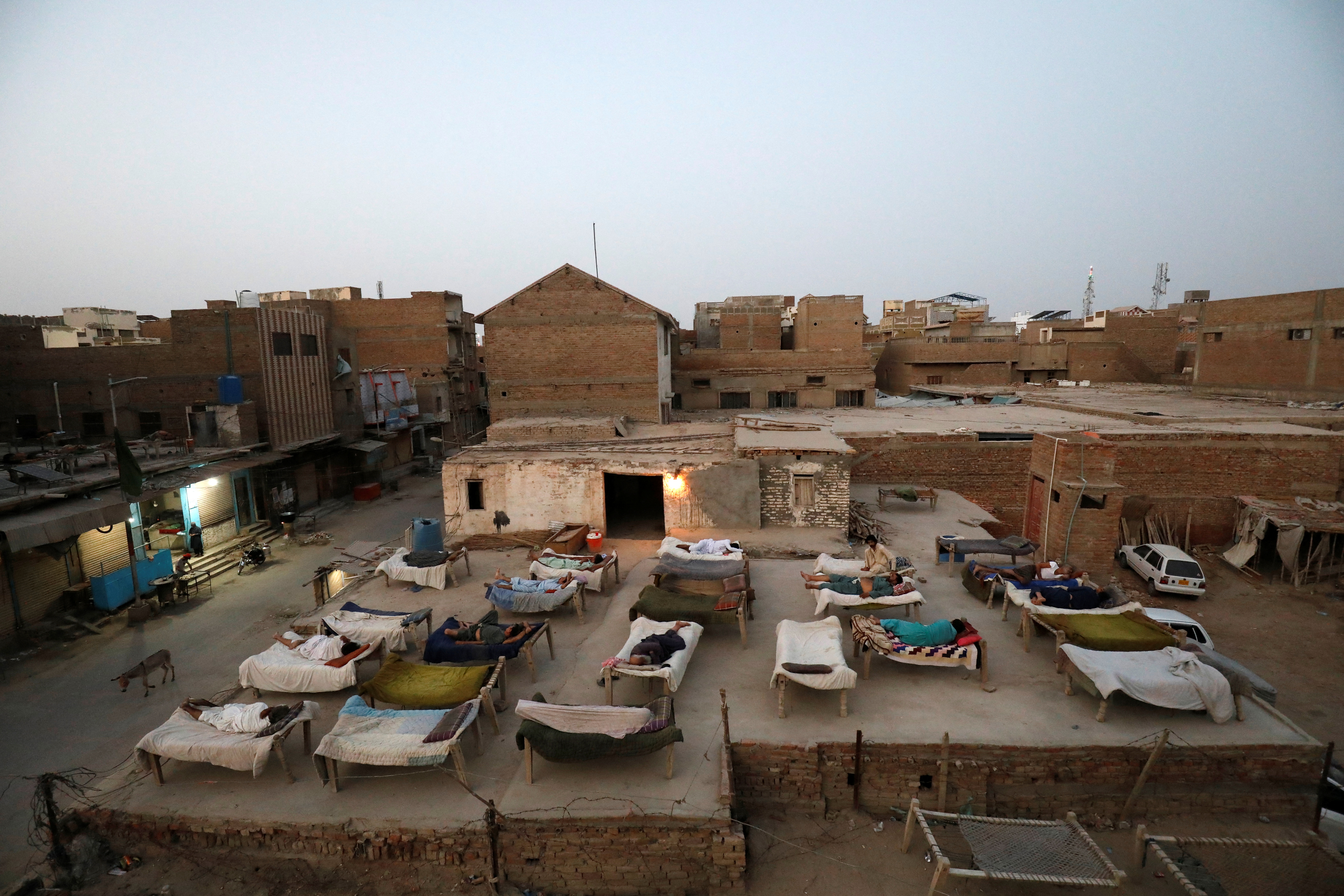 Men sleep on charpoy rope beds,
