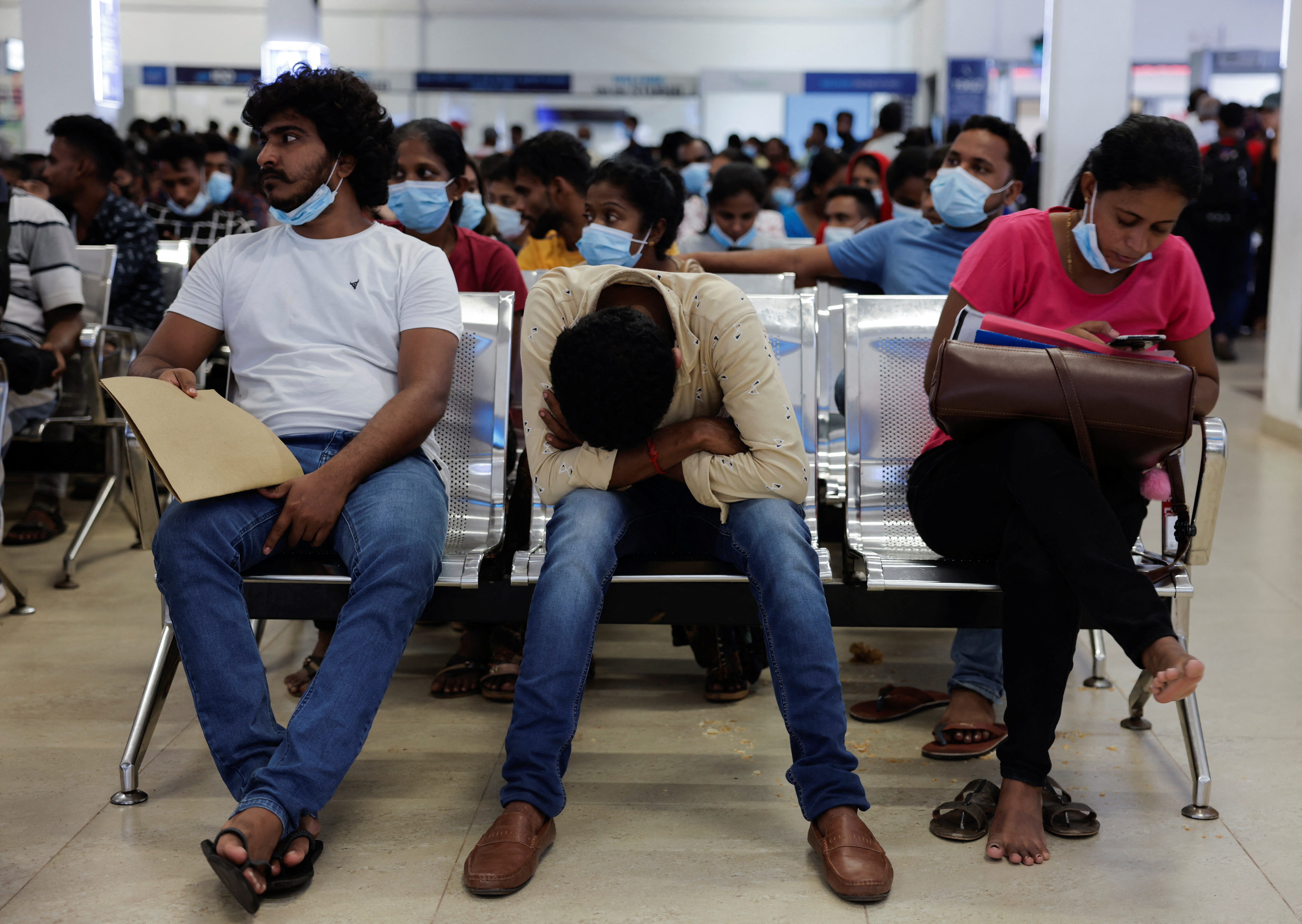 People wait to apply for a passport