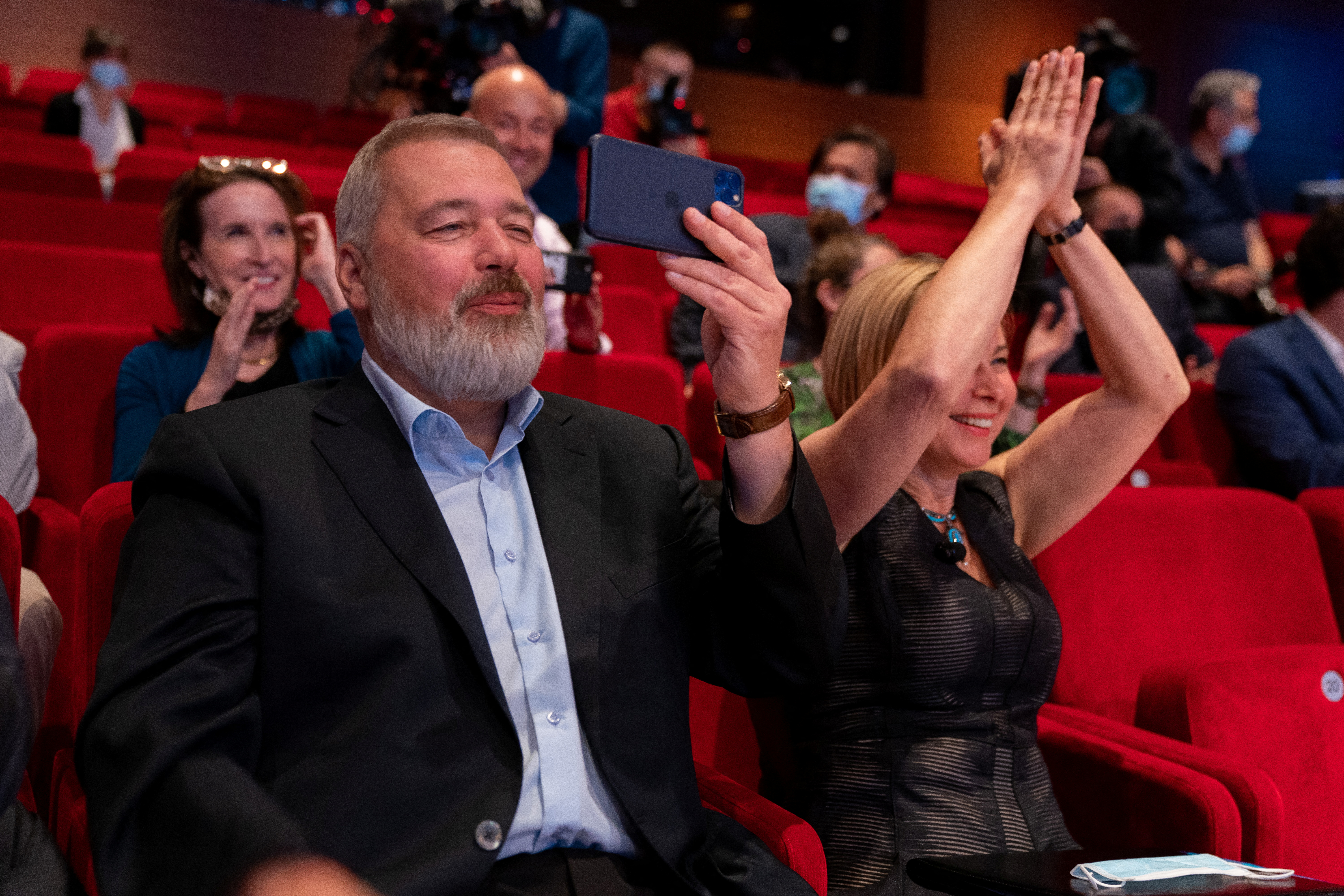 Dmitry Muratov watched and filmed the bidding for his 2021 Nobel Peace Prize medal with the audience breaking into cheers and applause