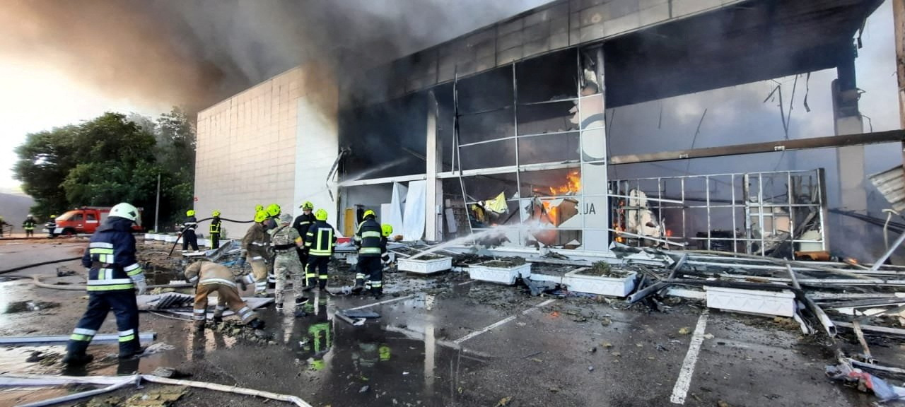 Rescuers put out fire at a shopping mall hit by a Russian missile strike in Kremenchuk, Ukraine [Press service of the State Emergency Service of Ukraine via Reuters]