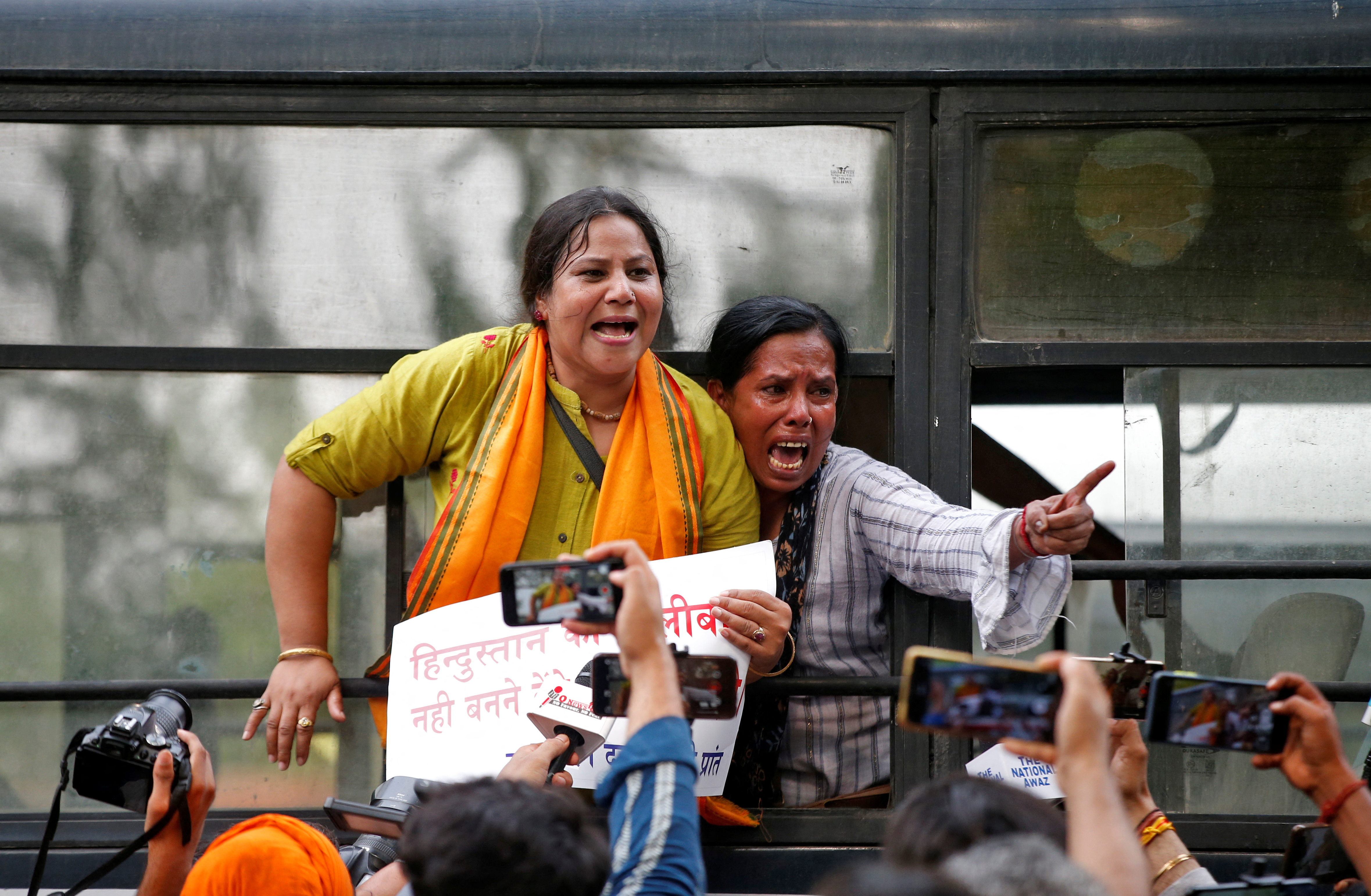 Members of Bajrang Dal, a Hindu far-right group, react after they were detained by police during a protest on Wednesday against the killing in Udaipur