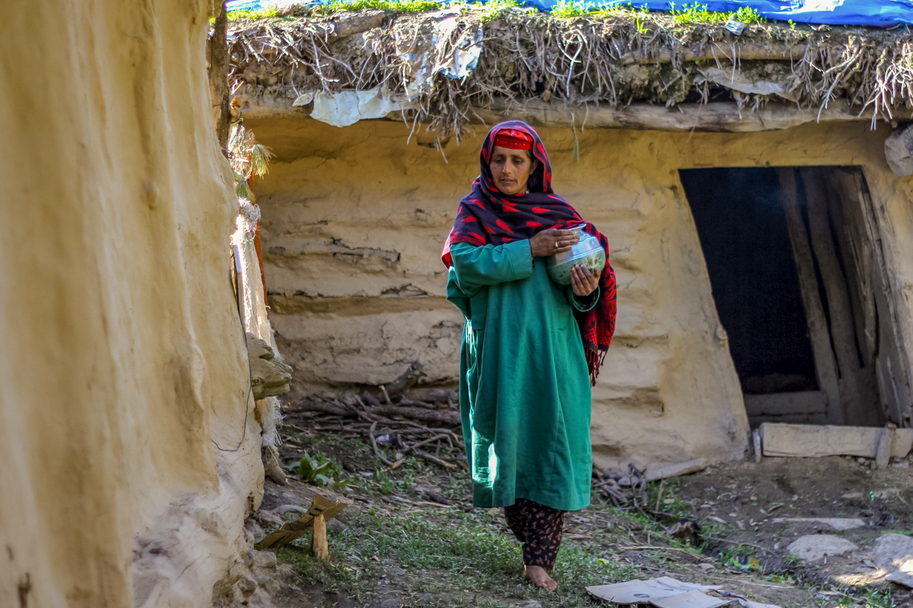 Zulaikha covers a milk-filled pot as she leaves the cowshed in Braaden. She saves milk for a week before making butter and kalari for the family and to sell at market