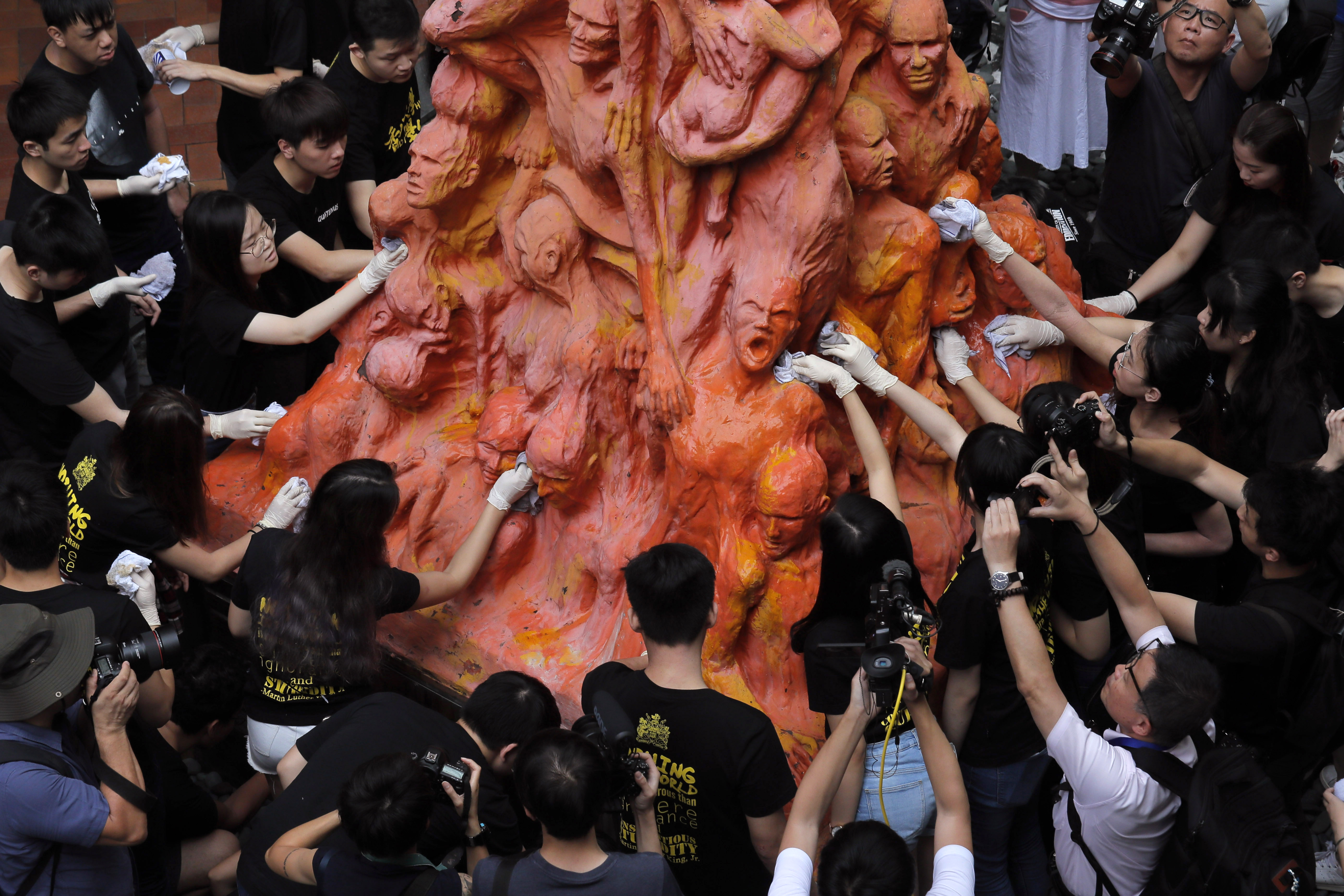 Students clean the tortured faces of the