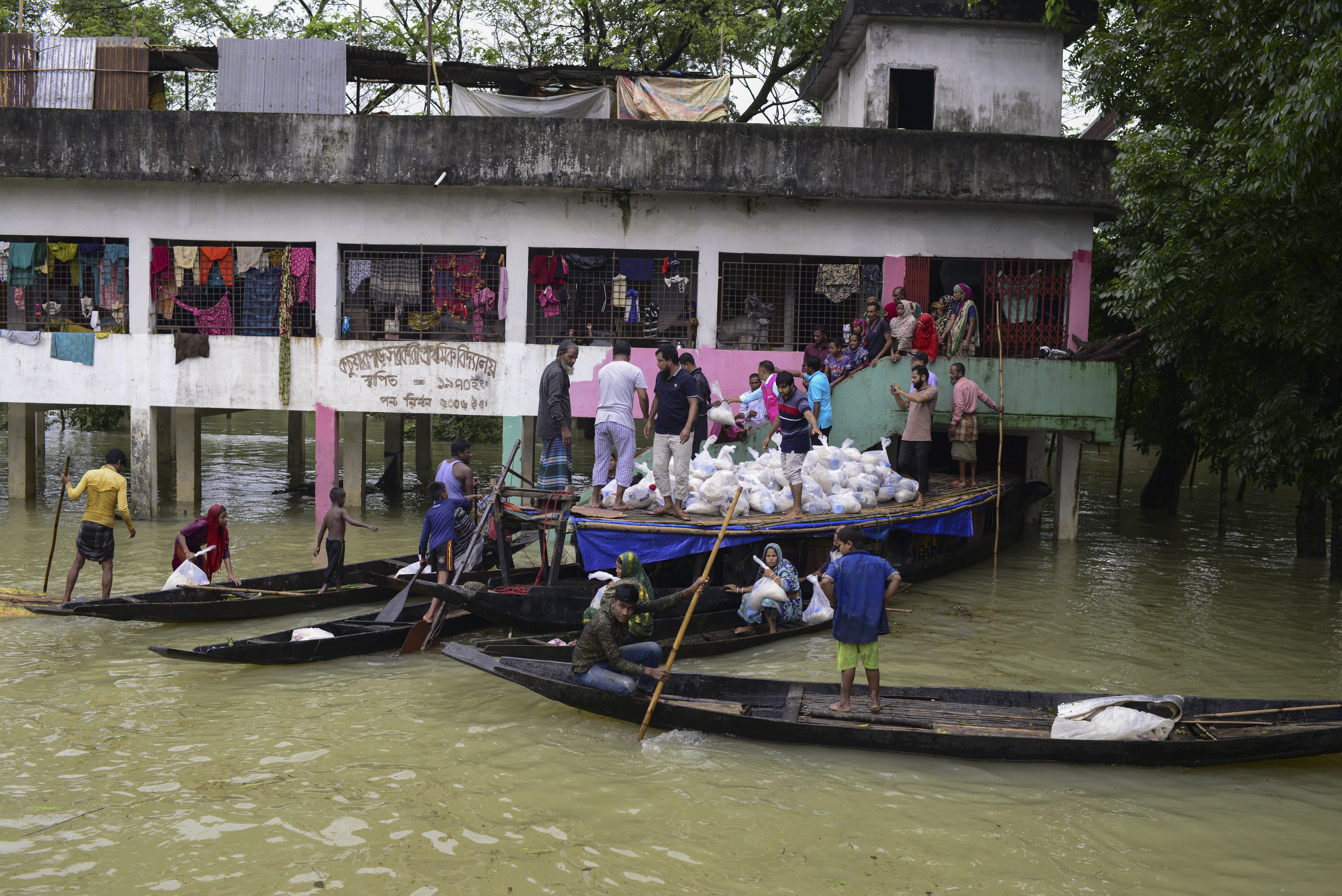 People receive relief materials at Companiganj in Sylhet, Bangladesh