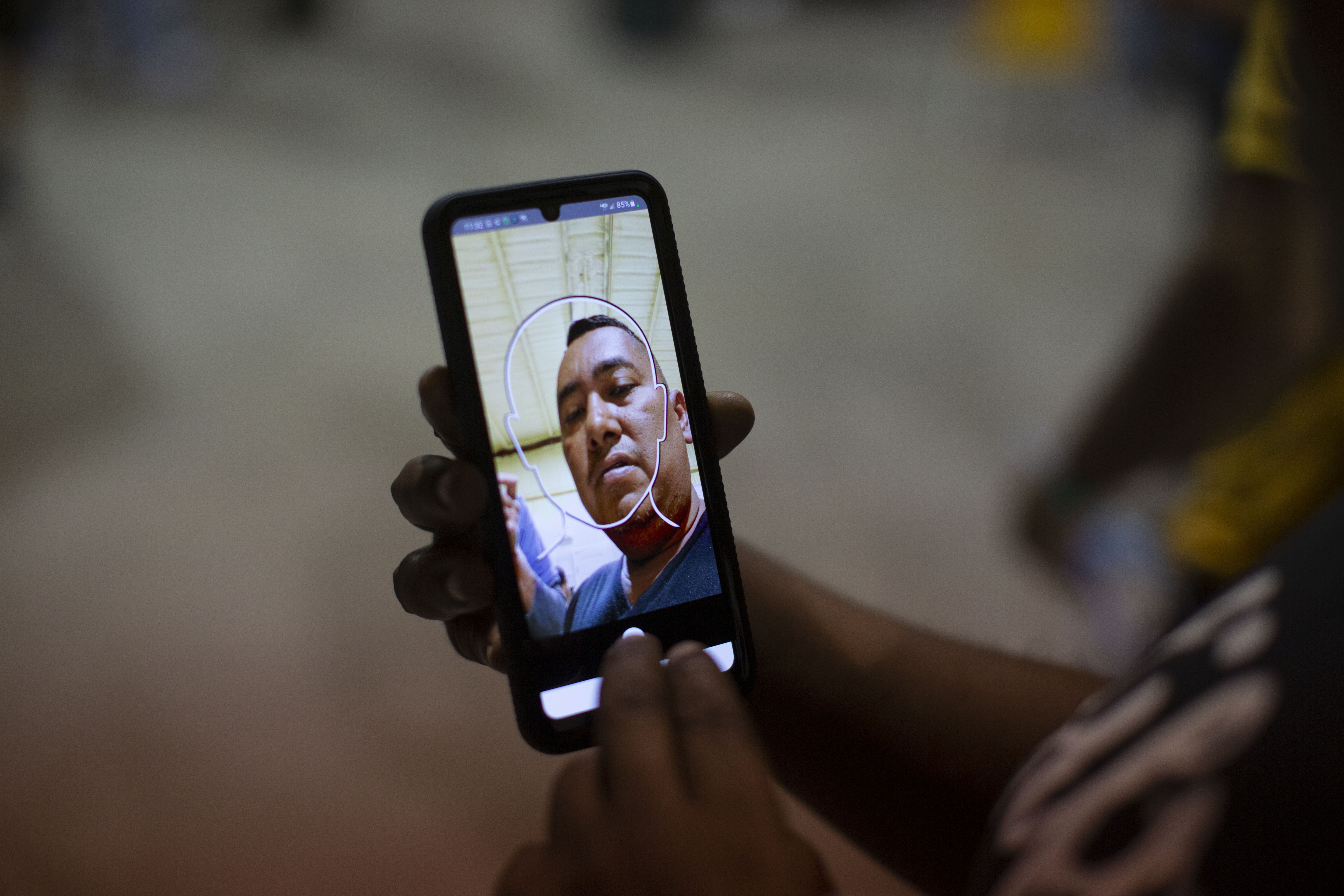 Jose Castillo, 43, who arrived from Nicaragua, like other migrants has to use a handheld device that tracks his movements