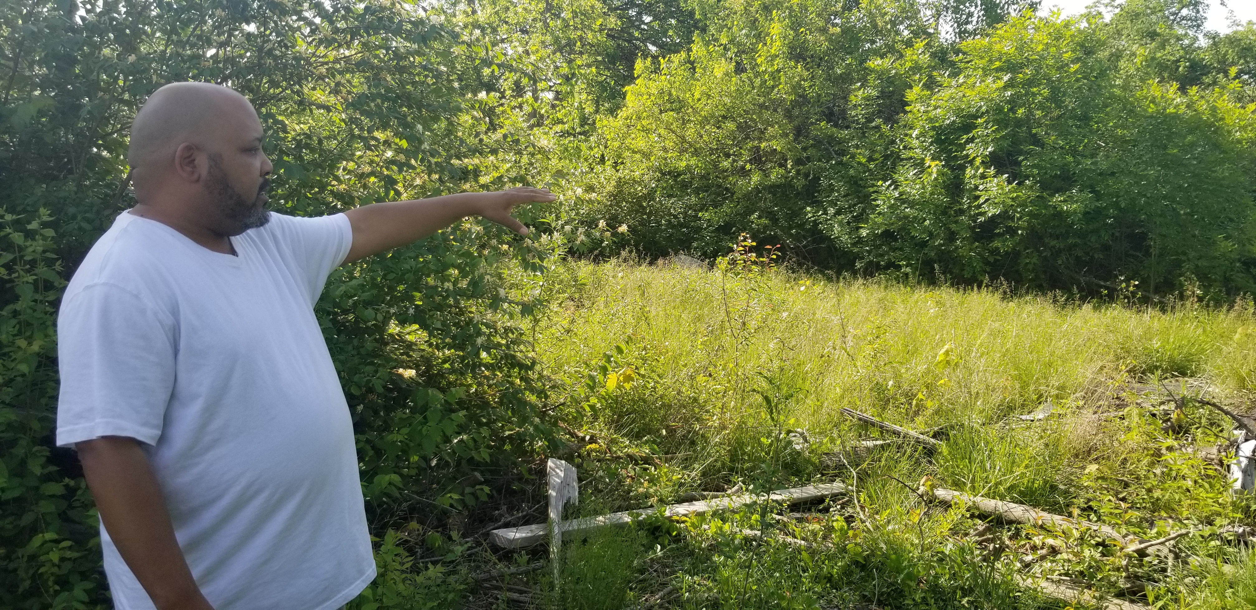 Derrick Stephens from Trotwood, Ohio, points to tree damage caused by a major tornado three years ago
