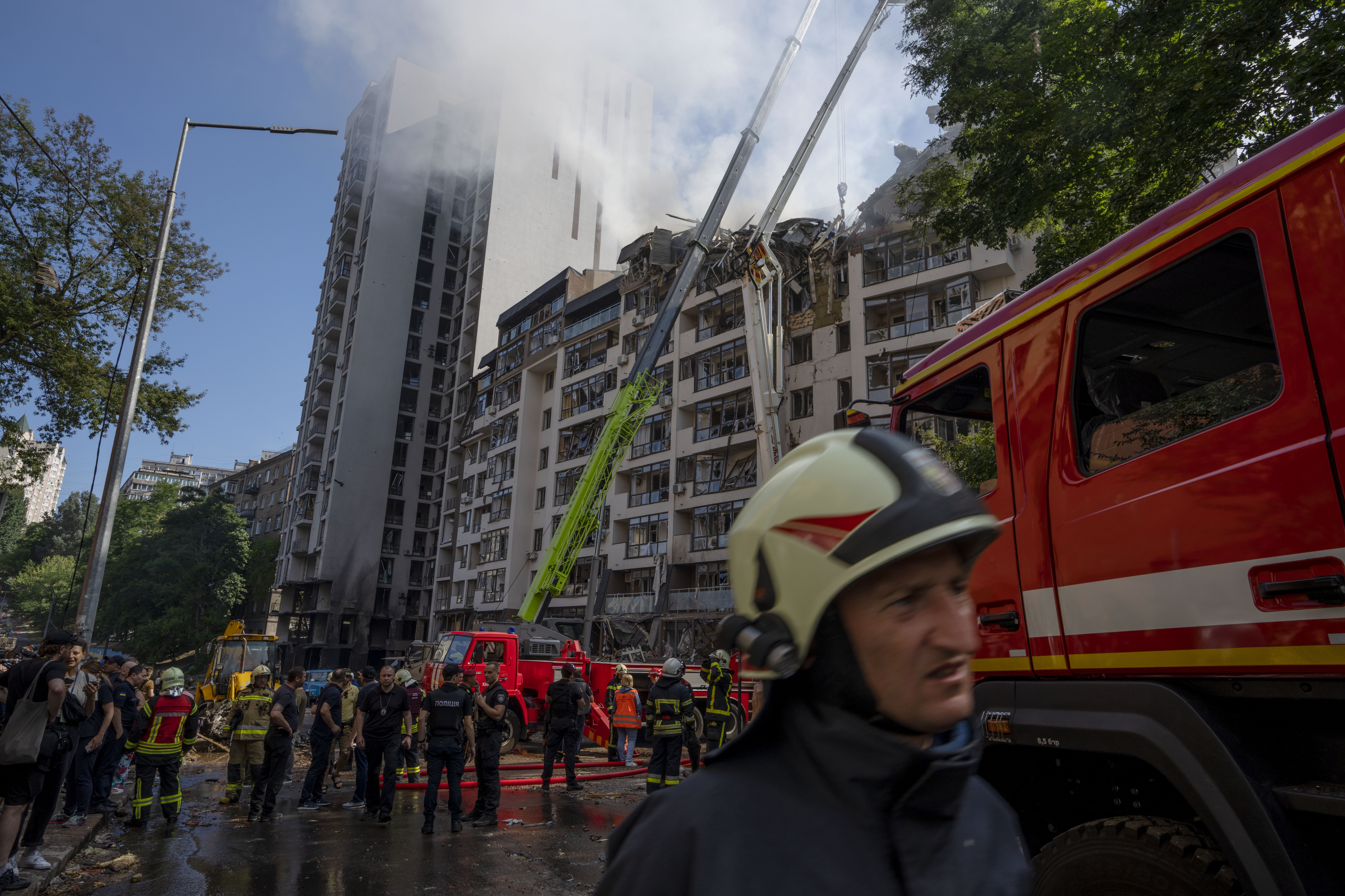 Firefighters work at the scene of a residential building following explosions in Kyiv, Ukraine, Sunday, June 26, 2022