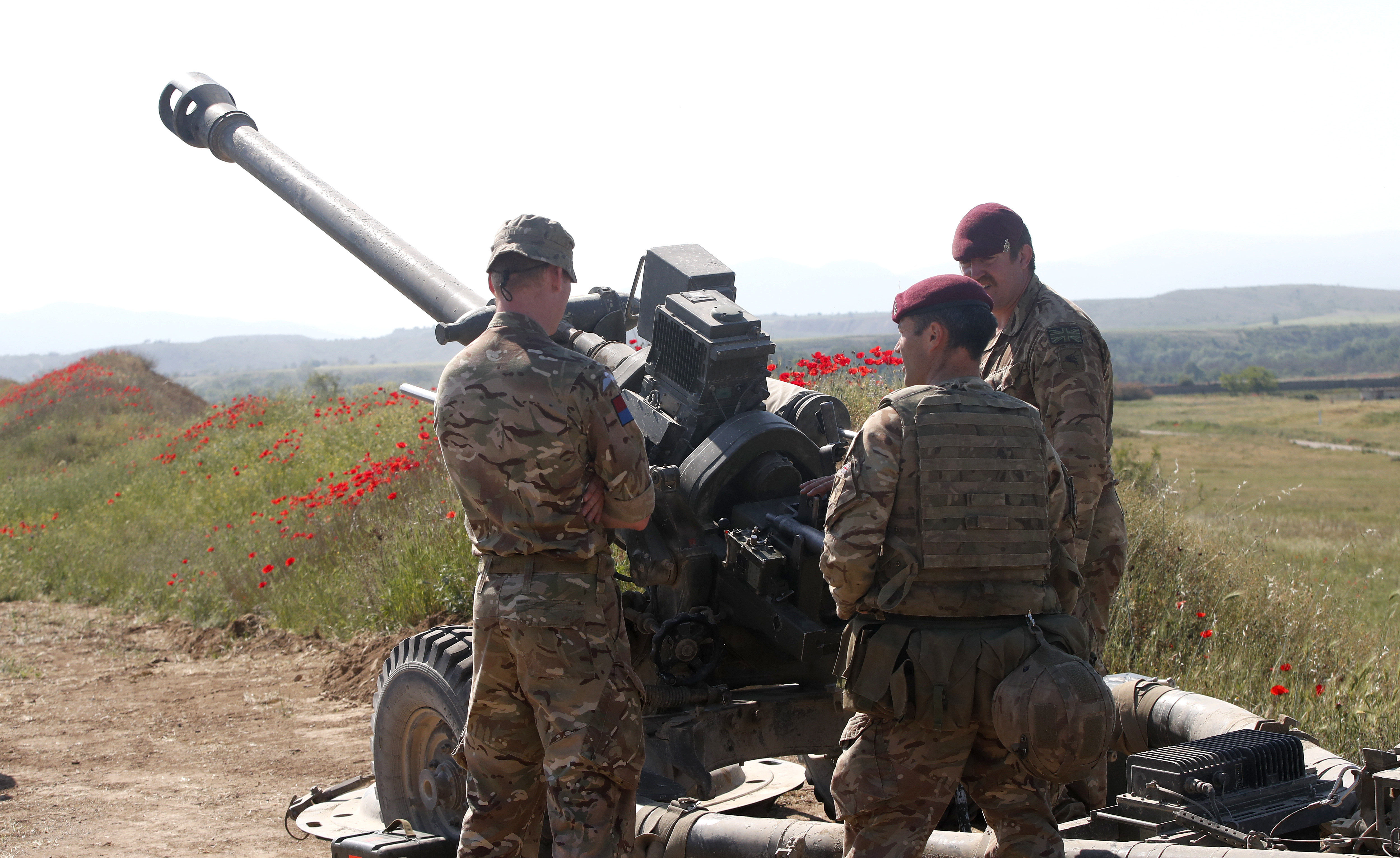 British soldiers from the 16 Air Assault Brigade stand next to a howitzer during the Swift Response 22 military exercise at the Krivolak army training centre in central North Macedonia on May 12, 2022
