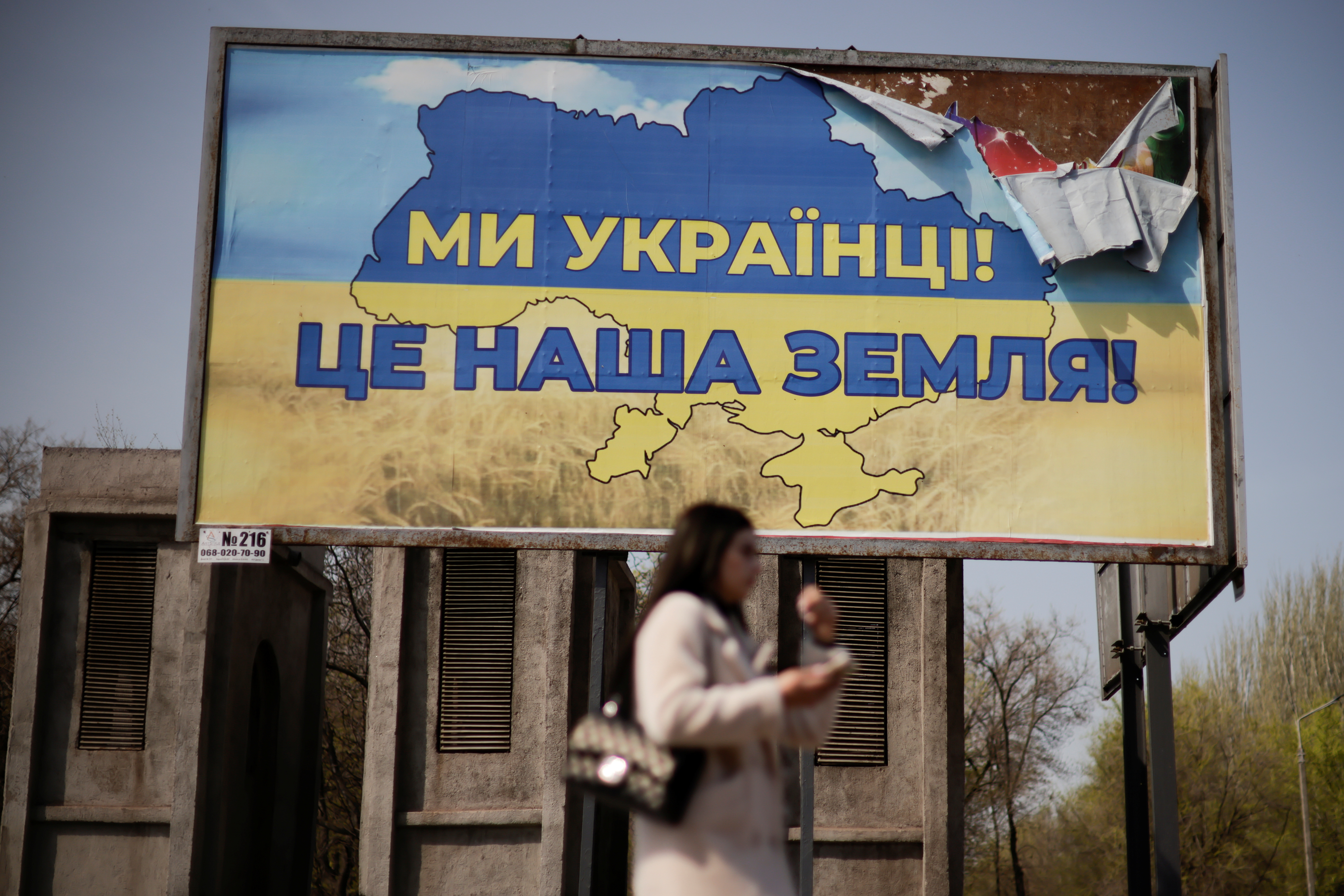 A Ukrainian woman passes in front of a billboard reading ‘We are Ukrainians, this is our land’, in the town of Kryvyi Rih, Dnipropetrovsk region, Ukraine on April 25, 2022