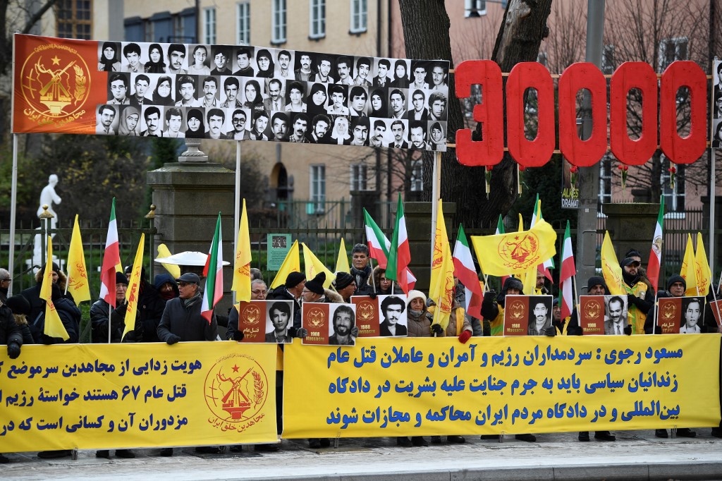 people demonstrate outside the Stockholm District Court in connection with the war crime trial against Hamid Noury 