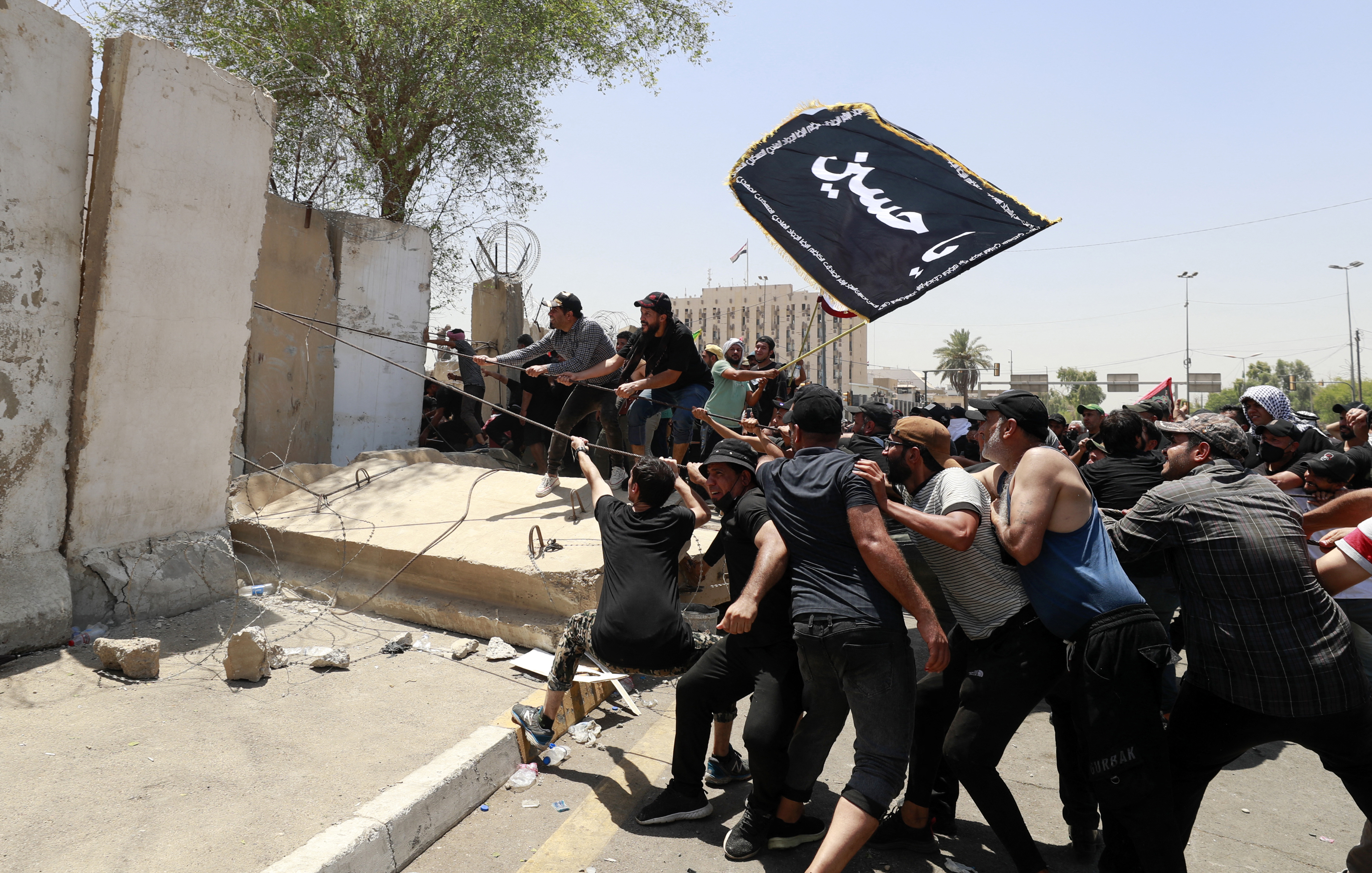 Supporters of the Iraqi cleric Moqtada Sadr bring down concrete barriers leading to the capital Baghdad's high-security Green Zone.