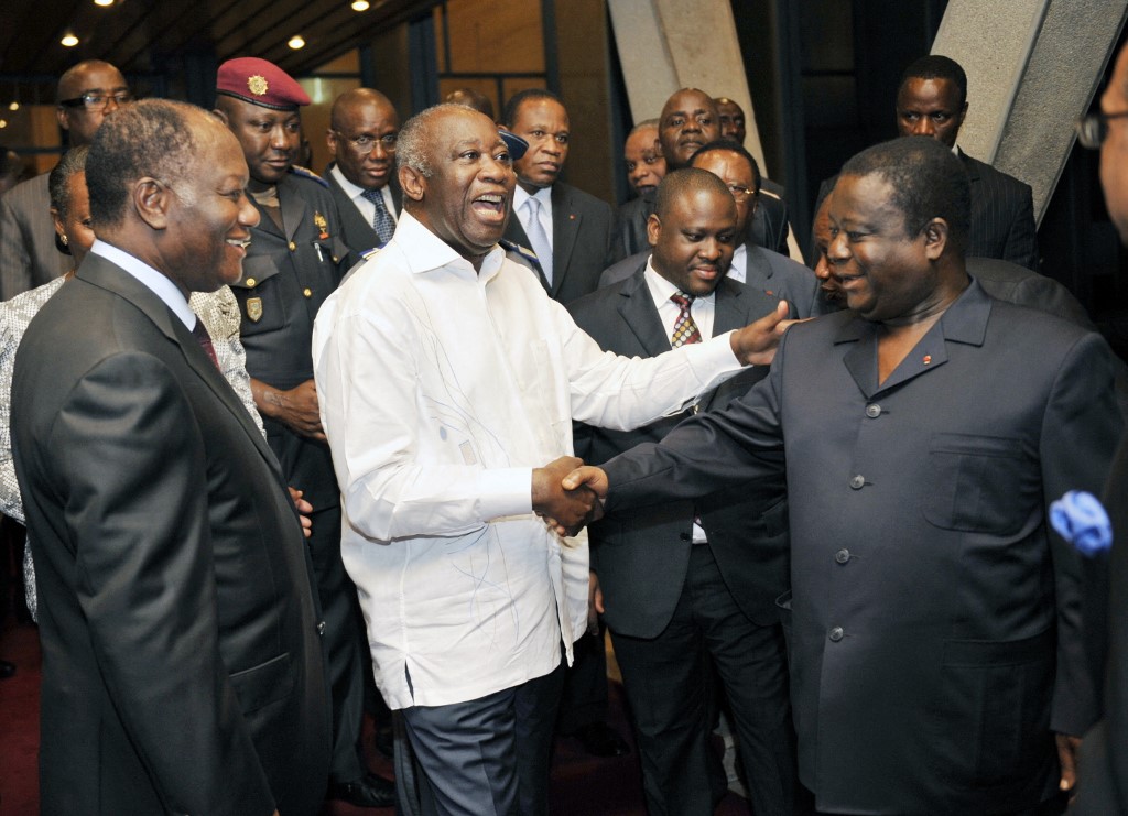 Current Ivorian president Alassane Dramane Ouattara (L) views the then president Laurent Gbagbo (C) shaking hands with another former President Henri Konan Bedie during a meeting held at the presidential palace in Abidjan on June 30, 2010