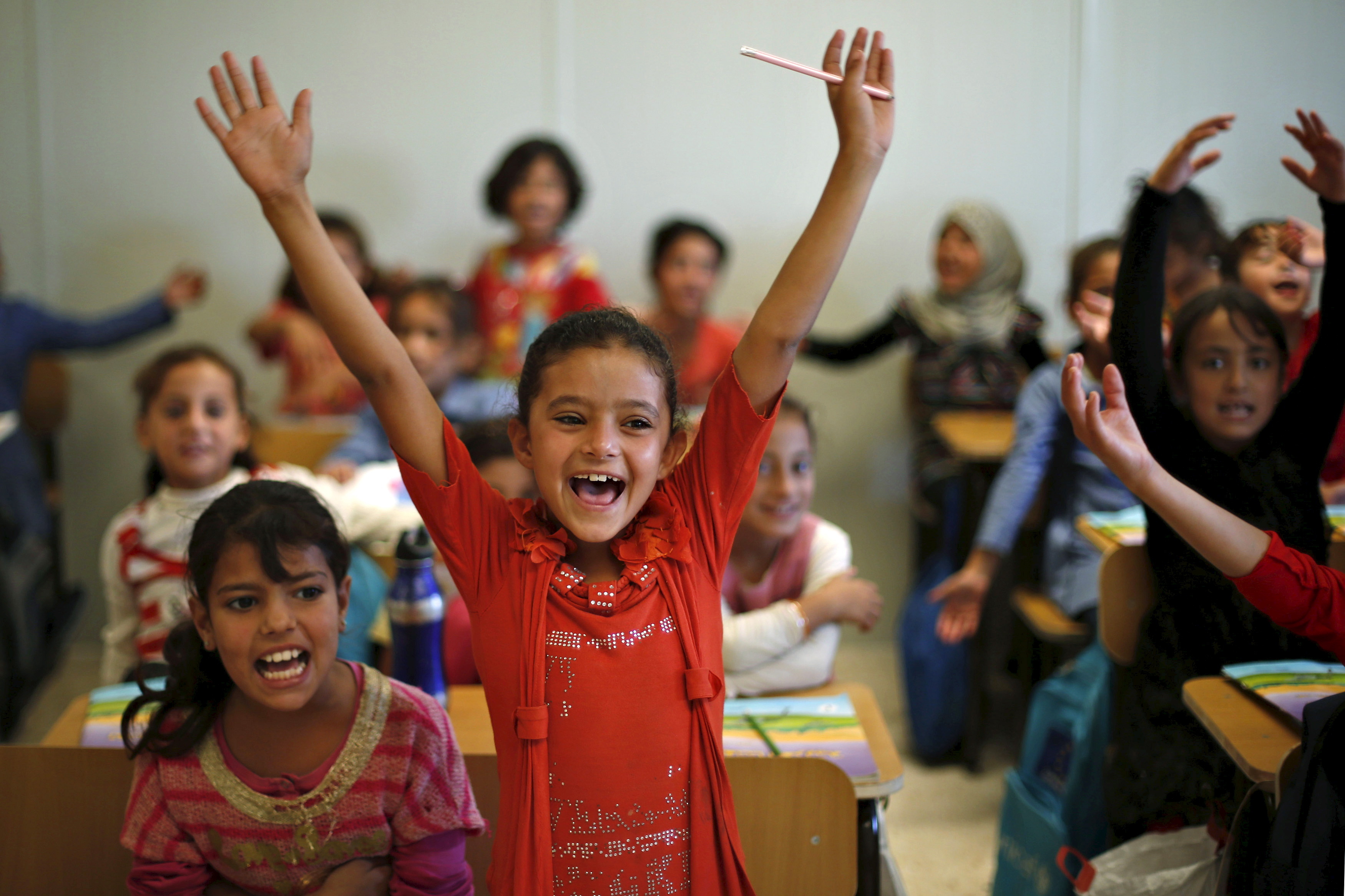 Syrian refugee students gesture while attending a class in a UNICEF school, September 22, 2015