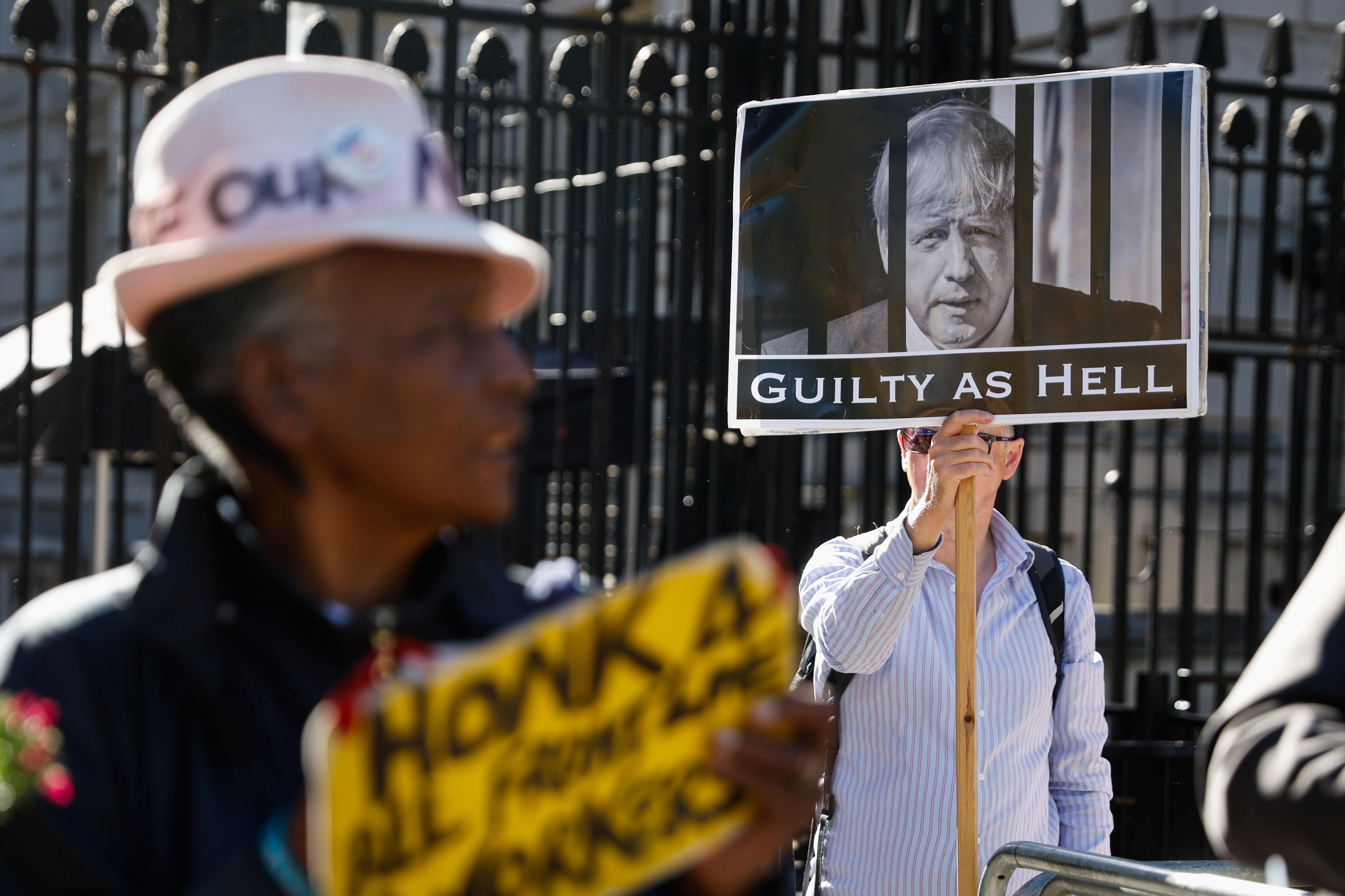 People hold banners as they take part in a demonstration in support of security guards and cleaners, who work in government offices following information detailed in the Sue Gray report into ‘Partygate’ in London