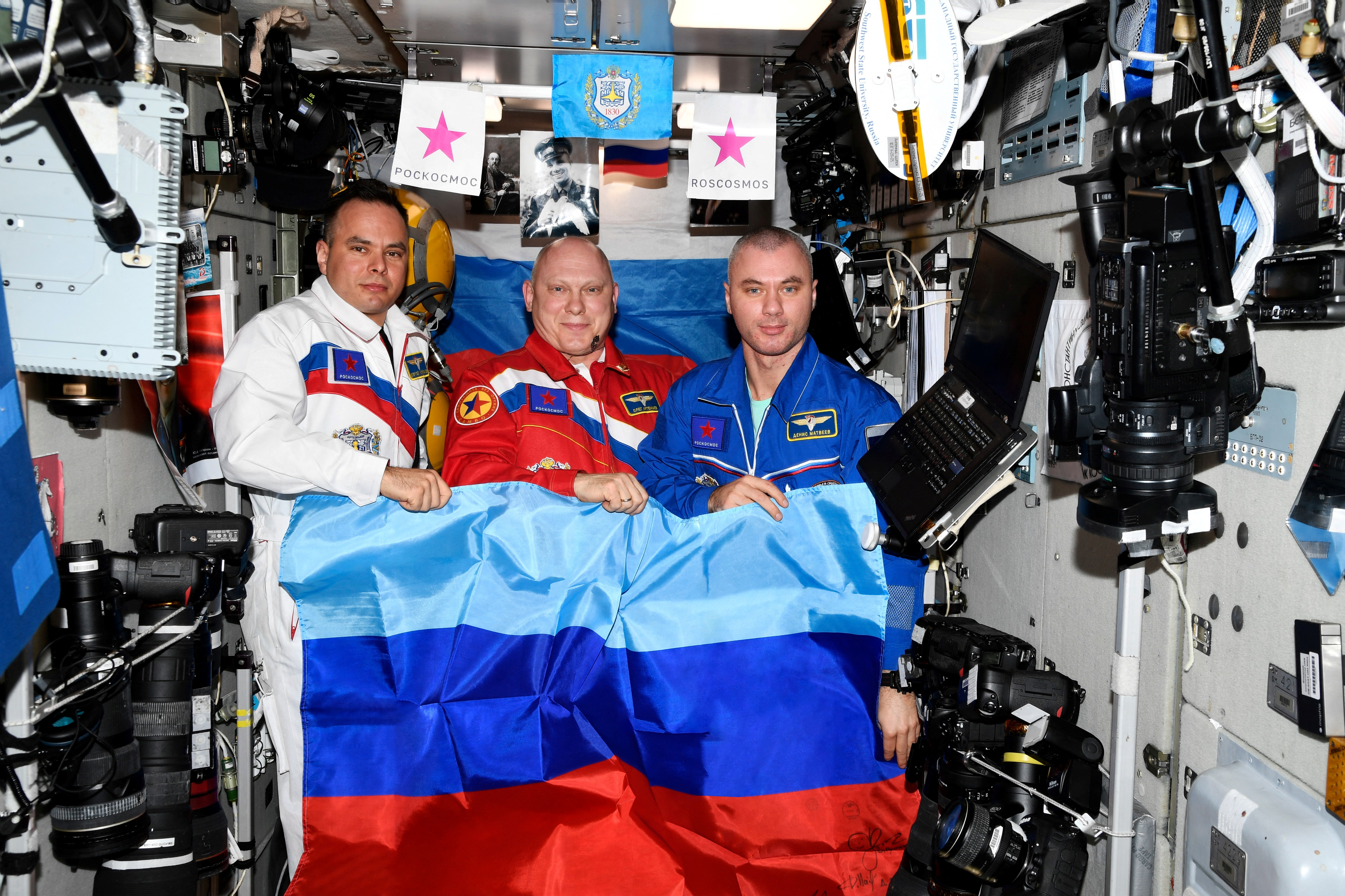 Russian cosmonauts Oleg Artemyev, Denis Matveev and Sergey Korsakov pose with a flag of the self-proclaimed Luhansk People’s Republic at the International Space Station