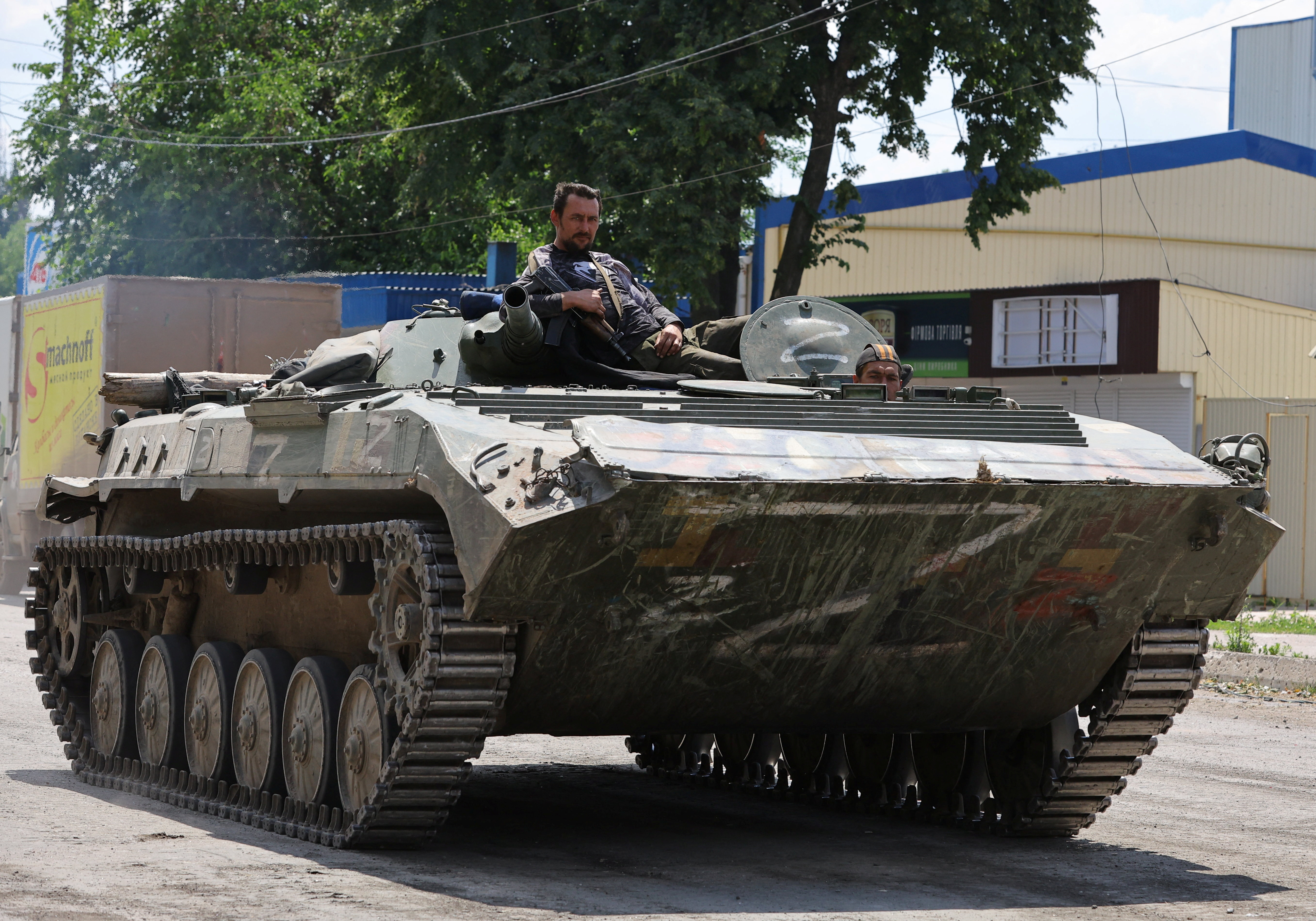 Service members of pro-Russian troops ride an infantry fighting vehicle in the city of Lysychansk in the Luhansk region