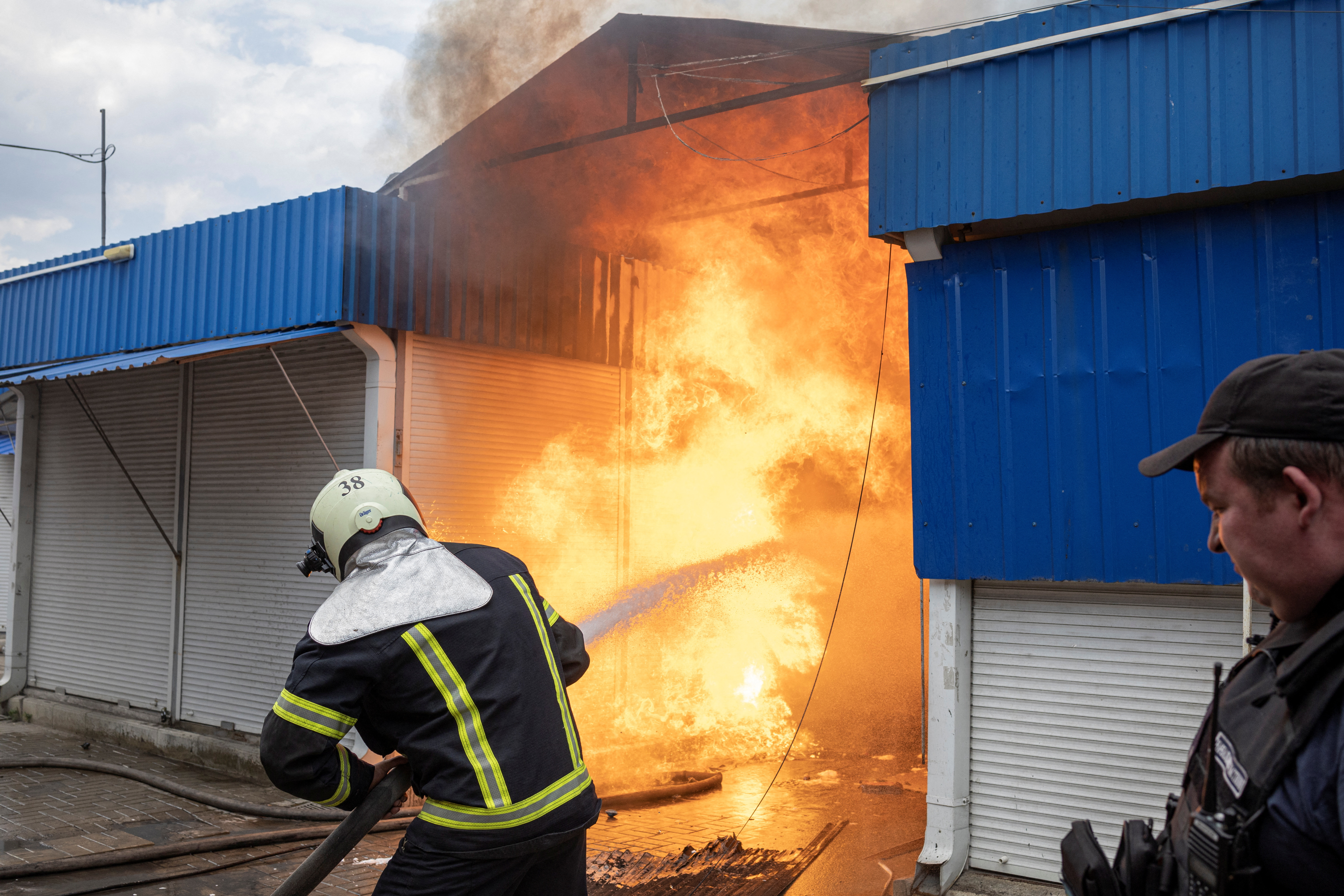 Firefighters spray water onto a fire in a market after Russian shelling in Sloviansk, Donetsk region, Ukraine, July 5, 2022