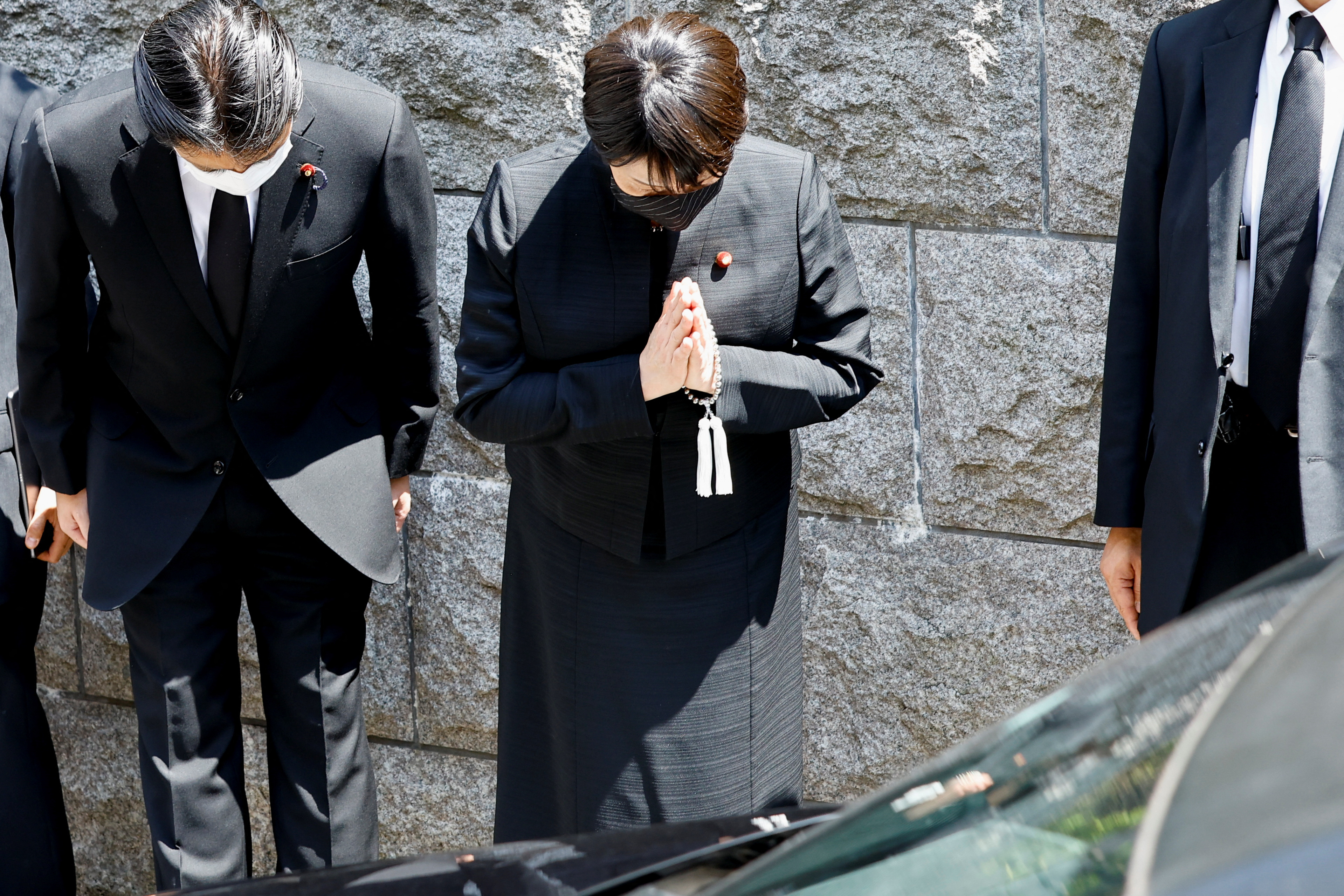 Japanese politicians pray to the vehicle believed to be carrying Abe’s body in Tokyo