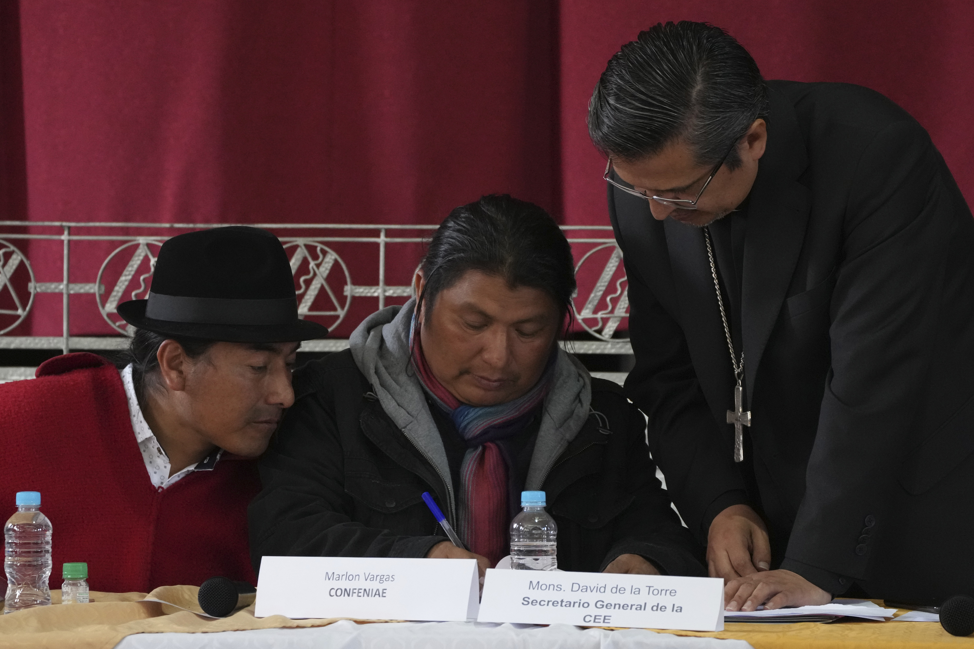 The deal was signed by Government Minister Francisco Jimenez, Indigenous leader Leonidas Iza (far left) and the head of the Episcopal Conference, Monsignor Luis Cabrera, who acted as mediator