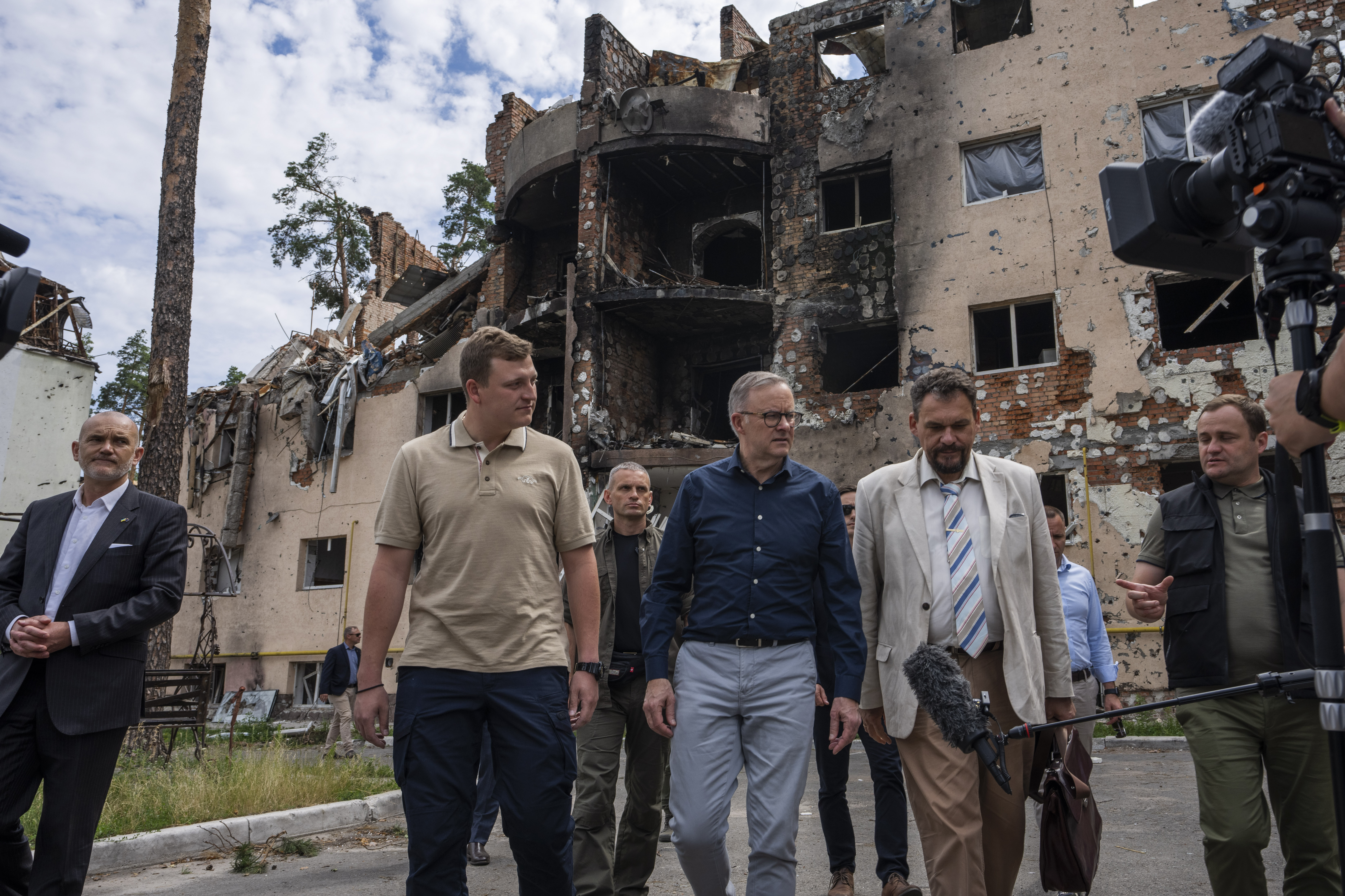 Australian Prime Minister Anthony Albanese, center, listens to a translator, during his visit to Irpin, on the outskirts of Kyiv, Ukraine, Sunday, July 3, 2022
