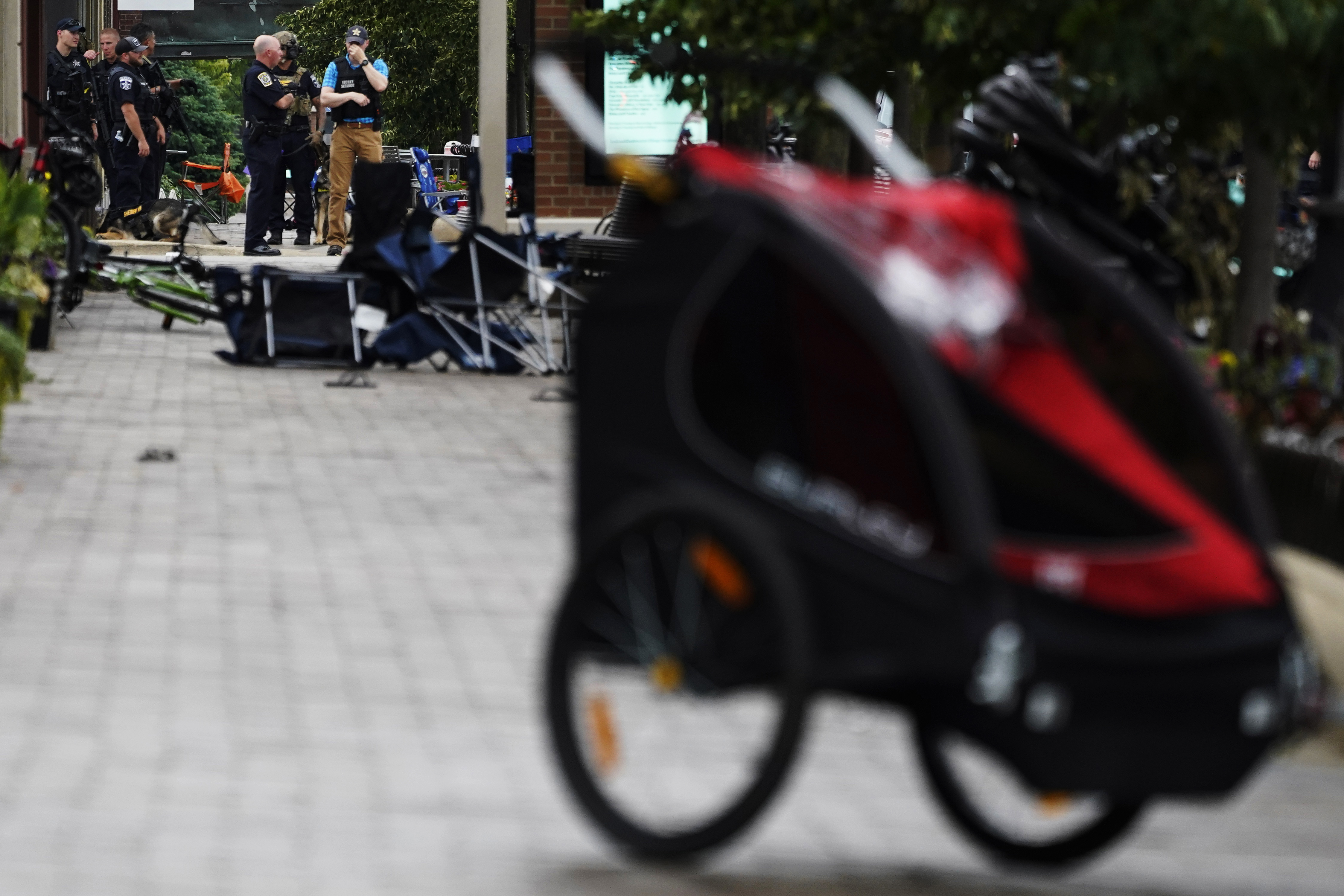 Law enforcement officers search downtown Highland Park after a deadly shooting