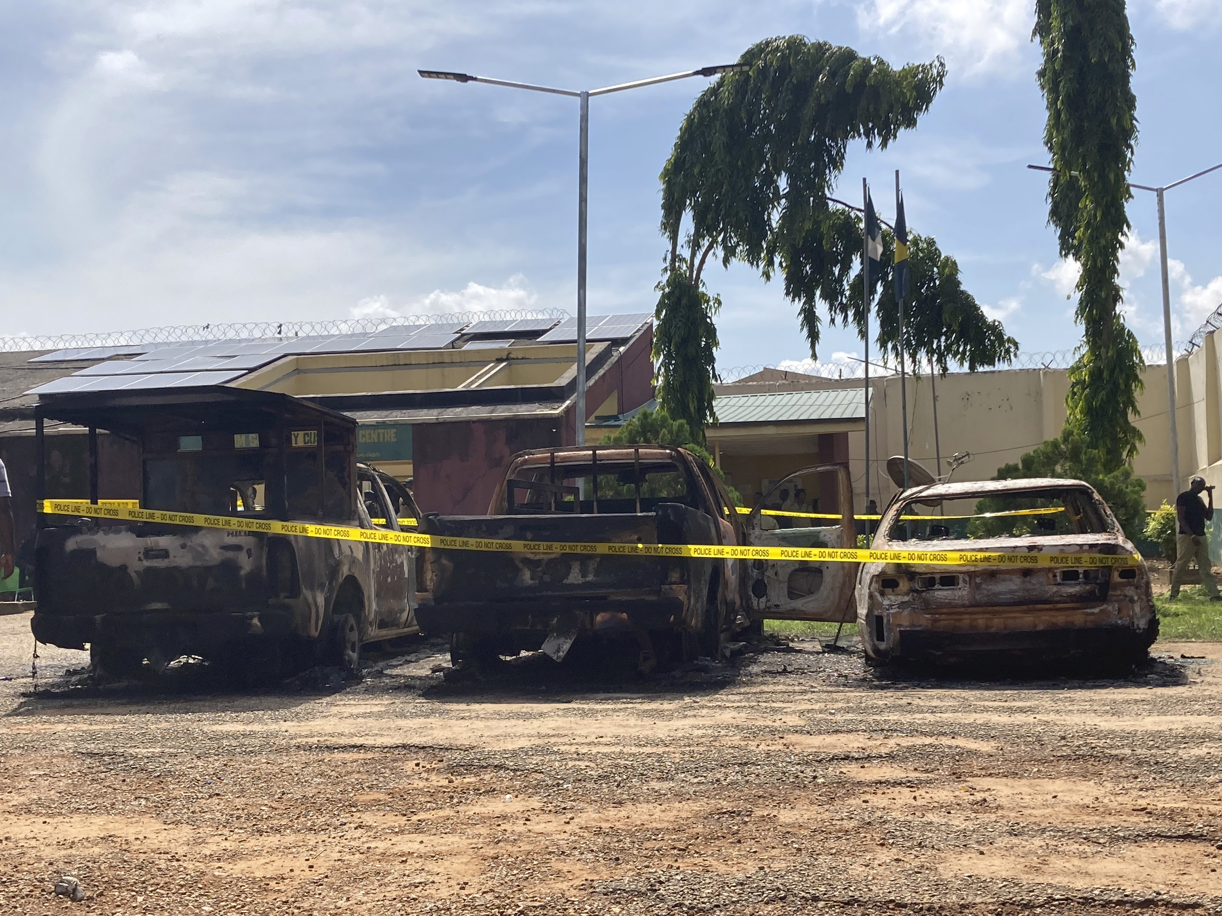 Charred cars are seen outside the Kuje maximum prison following the attack