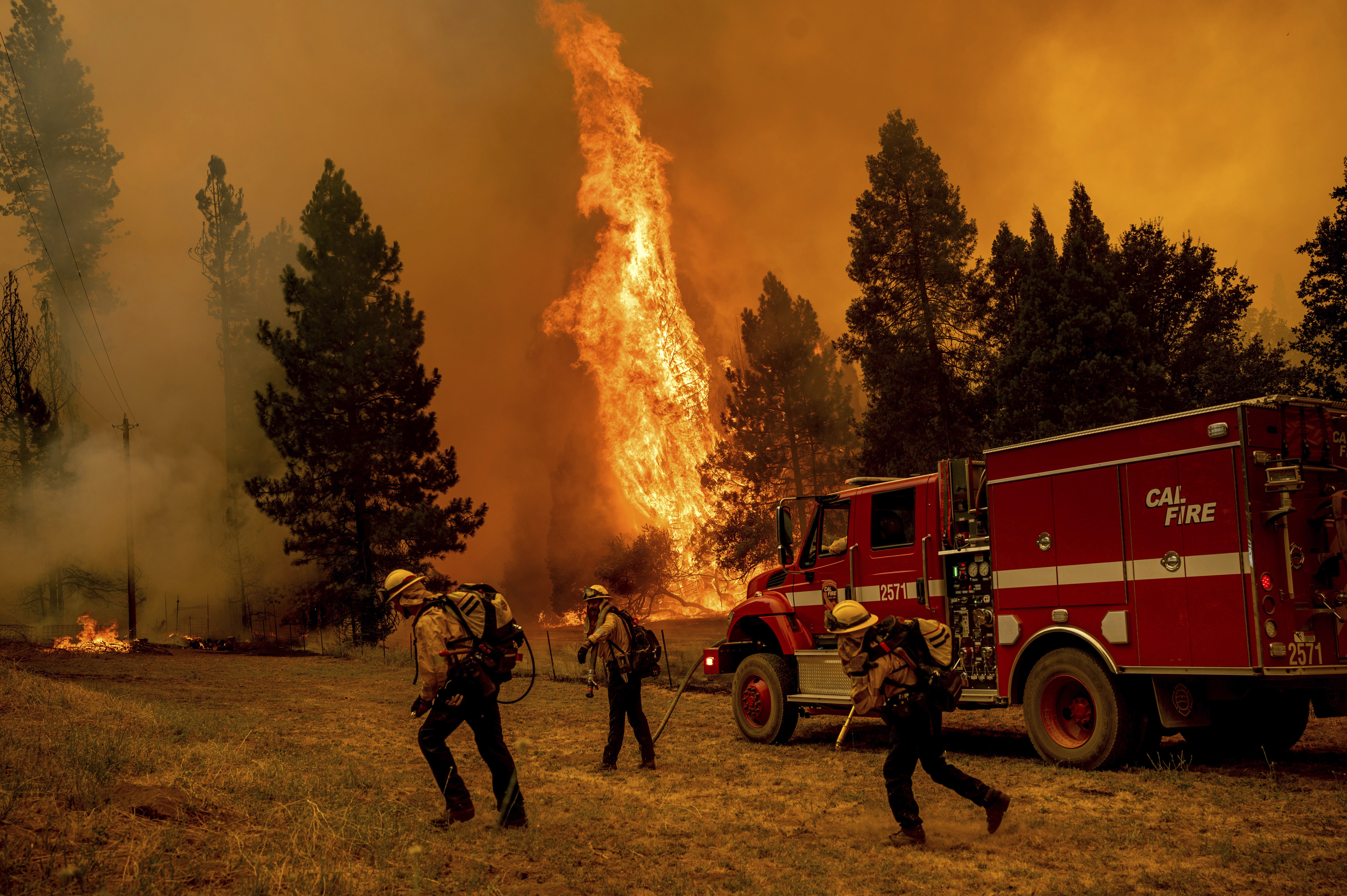 Firefighters work to keep the Oak Fire from reaching a home in the Jerseydale community of Mariposa County