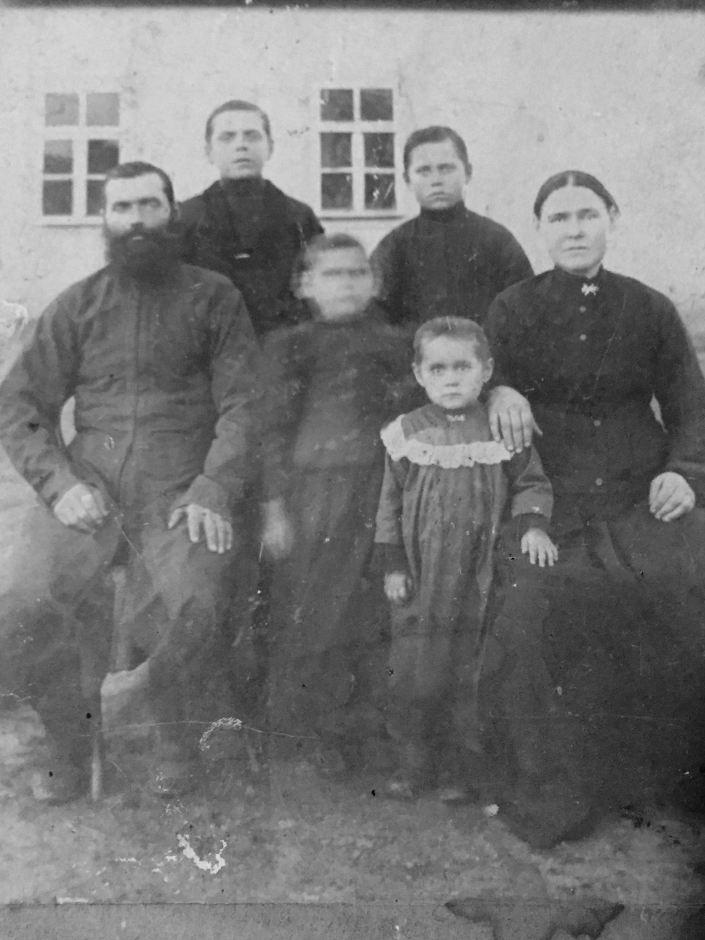 The author’s great-grandmother, Daria (the little girl with the frilled dress), with her family: Her mother with her hand on her shoulder, father on the other side, and siblings – most likely photographed around 1900 in a photo studio in Odesa with a backdrop of a farmhouse that looked like their own [Courtesy of Lara Dunston]