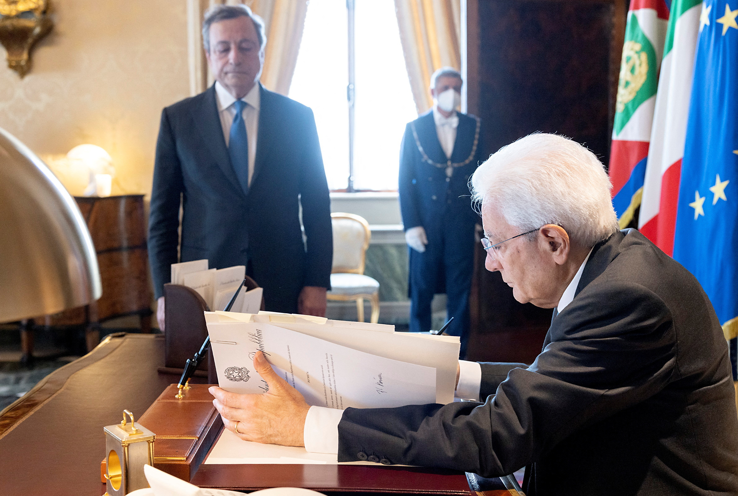 President Mattarella signs a document as he meets Draghi in Rome