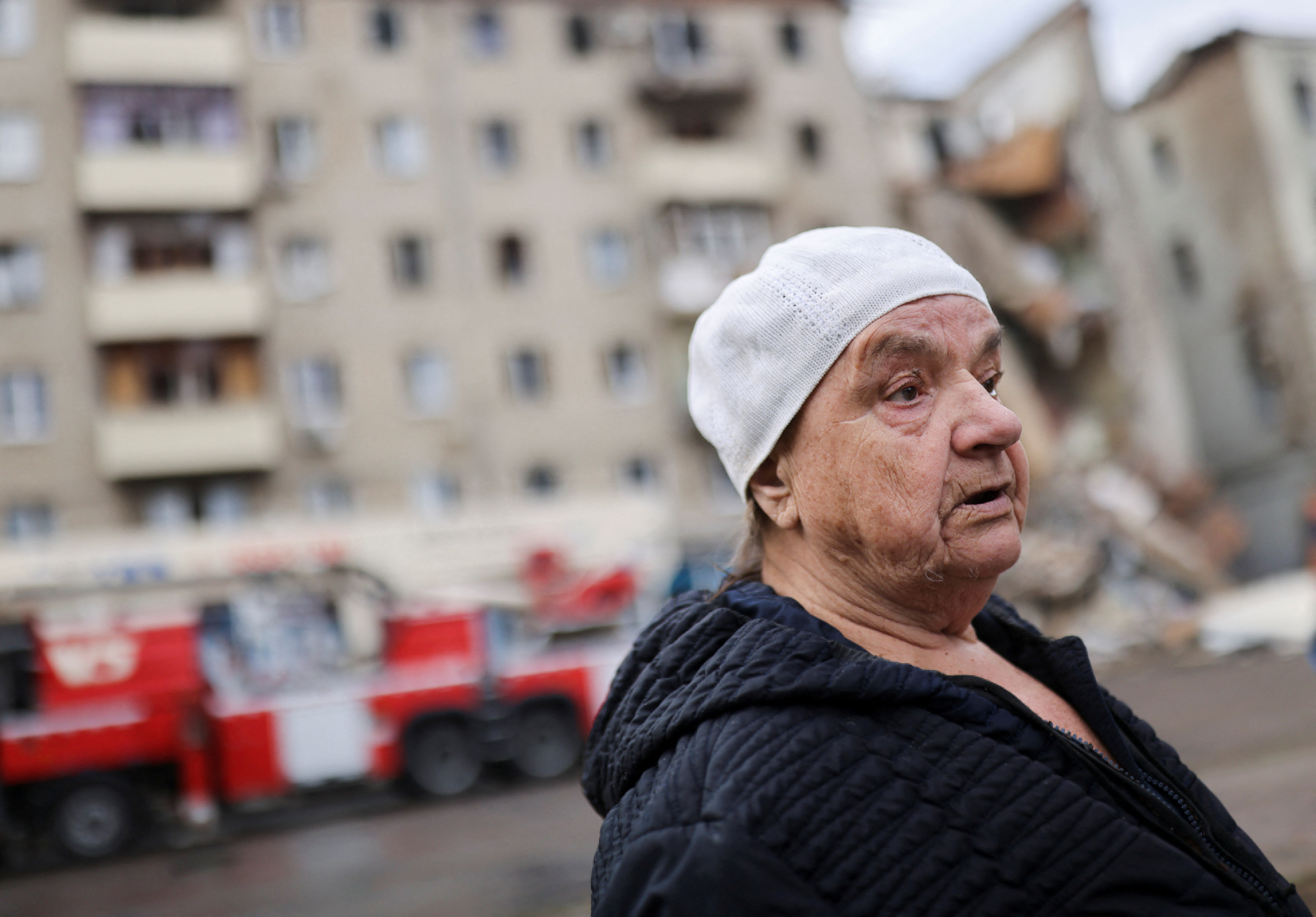 Valentina Popovichuk, who was rescued from a residential building after Russian shelling, stands in front of her destroyed apartment block in Kharkiv, Ukraine, July 11, 2022