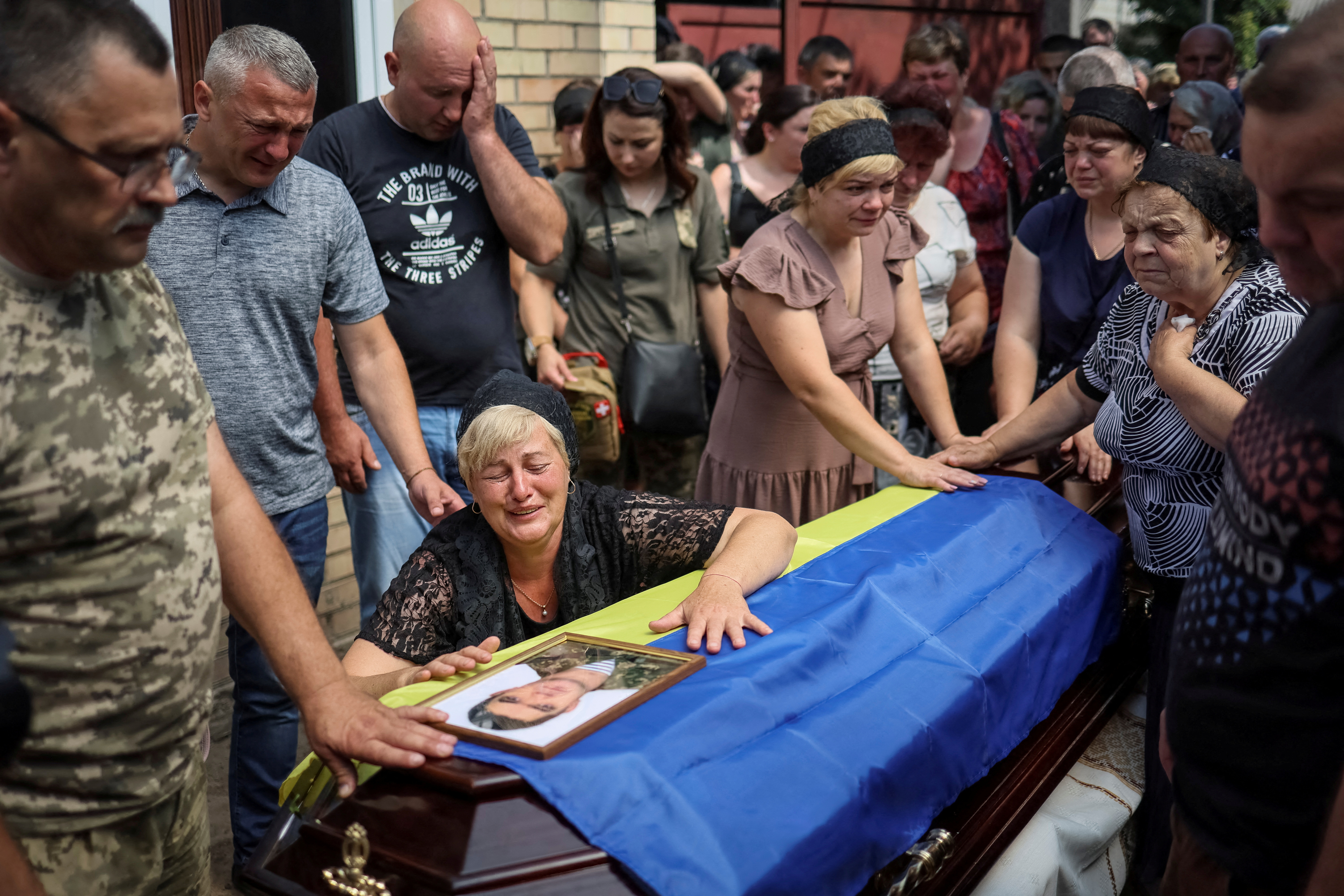 Natalia, the wife of Ukrainian serviceman Volodymyr Kochetov, 46, who was killed in a fight during Russia’s invasion, reacts during his funeral in the village of Babyntsi, Ukraine on June 30, 2022