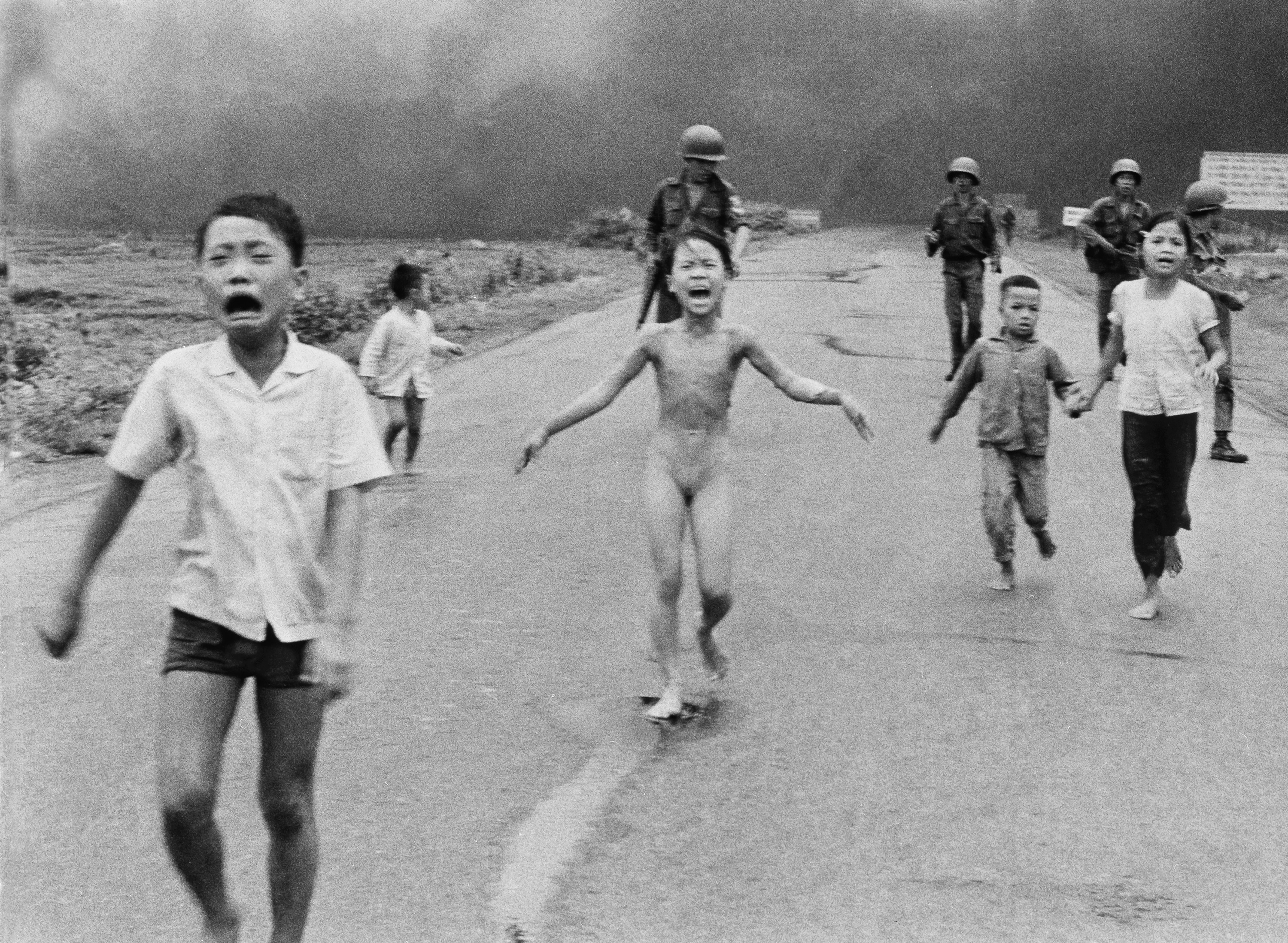 Nine-year-old Kim Phuc, centre, runs with her brothers and cousins, followed by South Vietnamese forces, down Route 1 near Trang Bang after a South Vietnamese plane accidentally dropped its flaming napalm on its own troops and civilians, June 8, 1972. The terrified girl had ripped off her burning clothes while fleeing