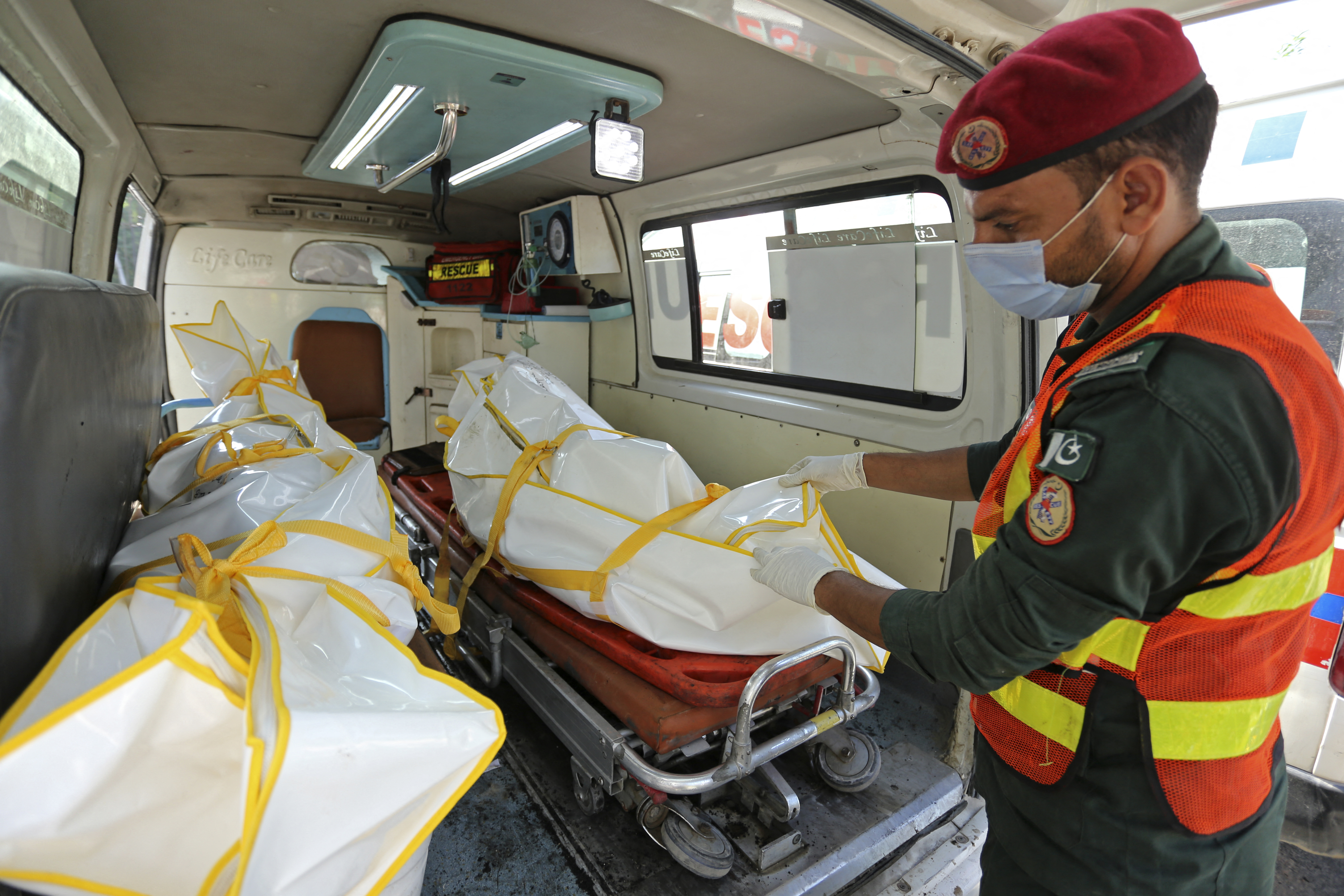 A rescue worker prepares to shift the burned bodies of victims to a hospital